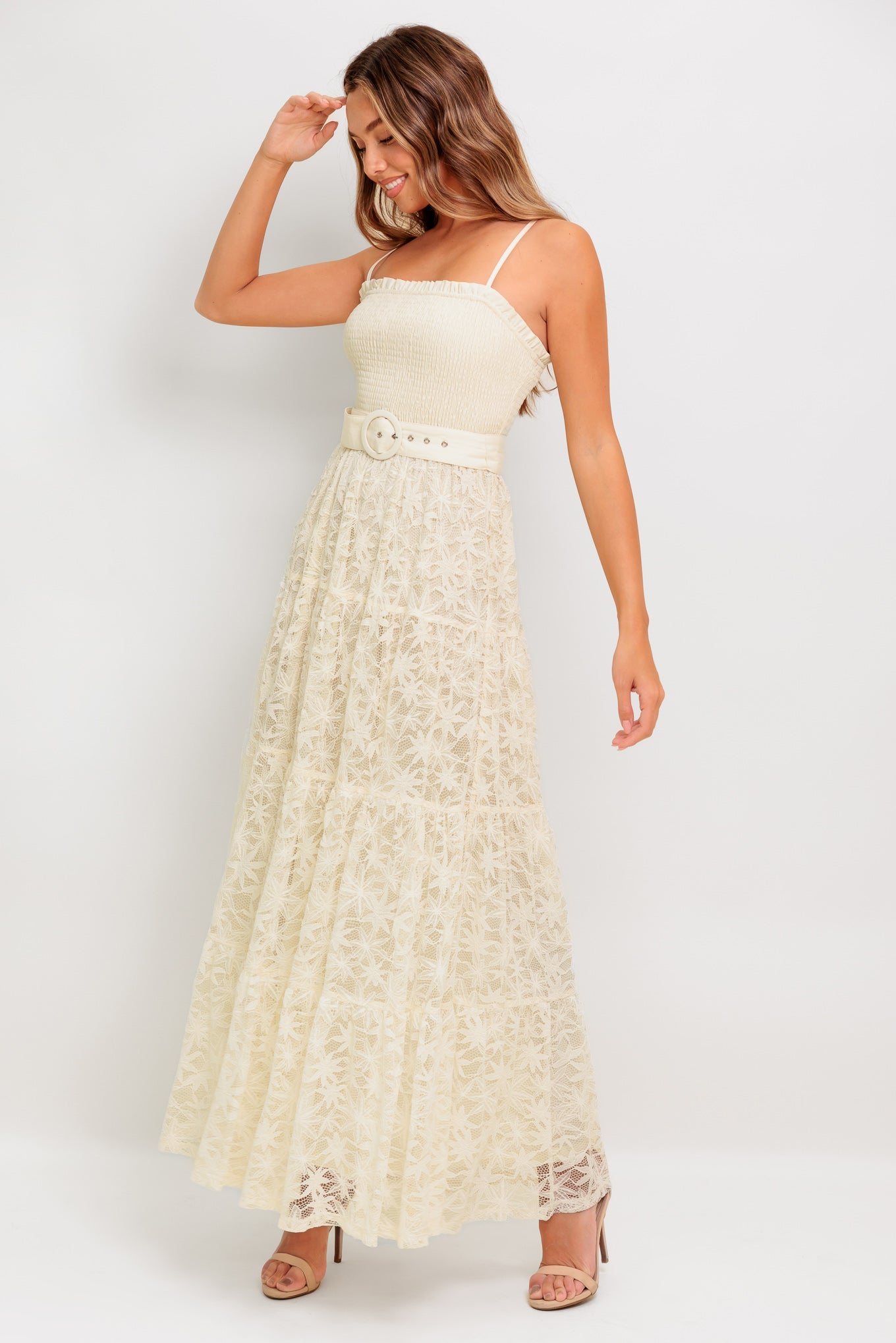 A woven lace ankle length dress featuring straight neckline with ruffled edge, smocked bodice, straps, self belt and tiered skirt