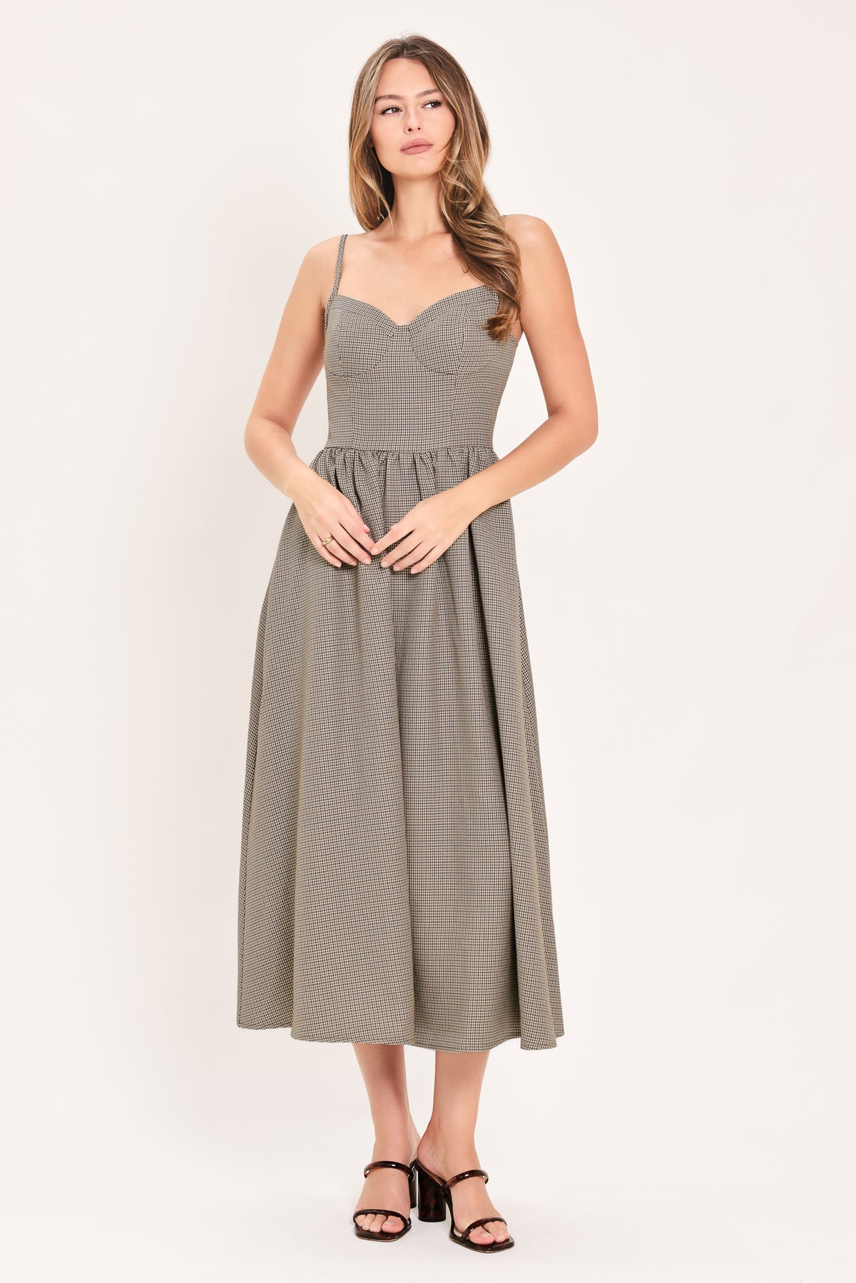 A woman wearing a plaid taupe and brown spaghetti strap midi dress | Flying Tomato