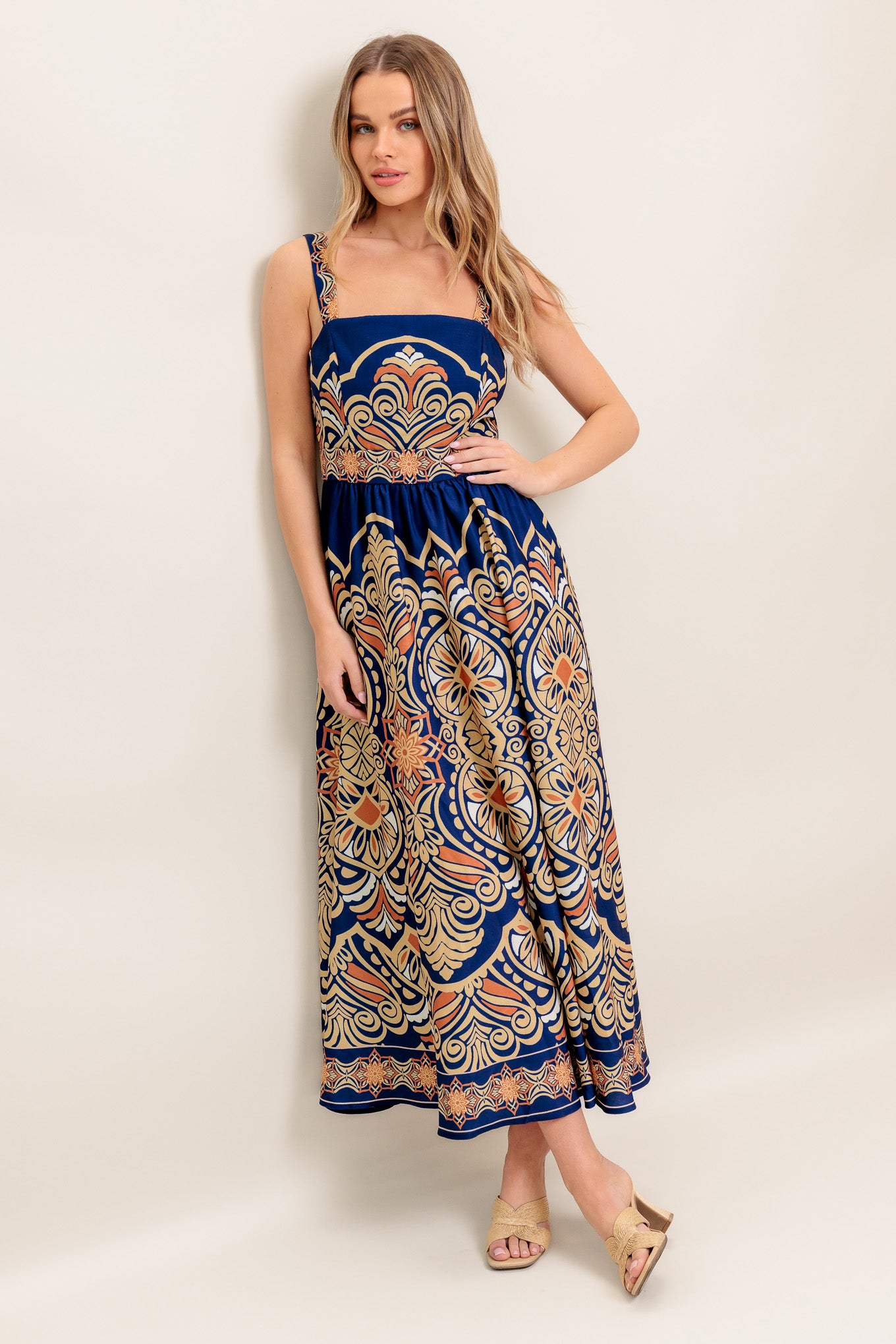 A printed woven midi dress featuring straight neckline, straps, full skirt and back zipper closure