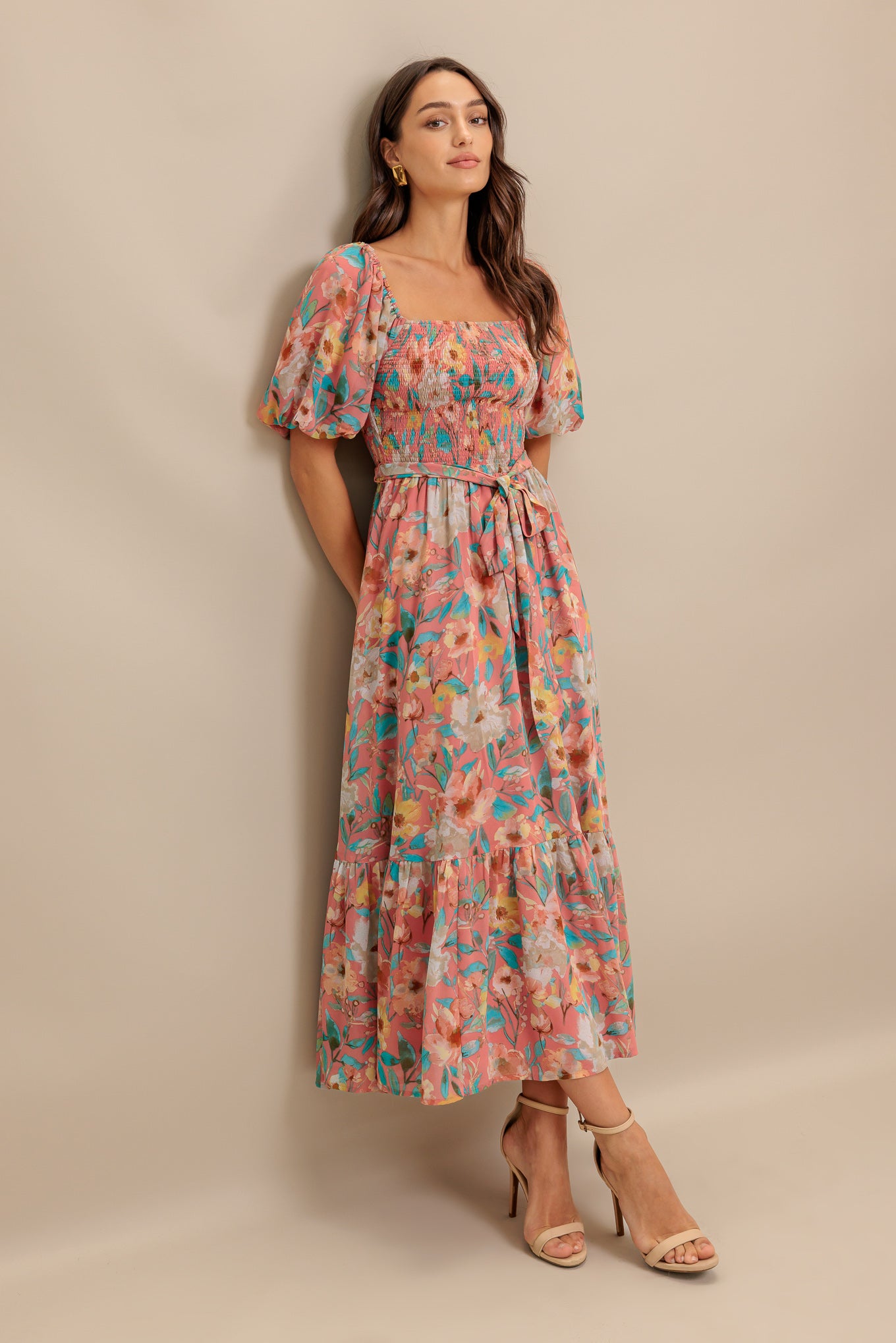 A printed woven midi dress featuring square neckline, short puff sleeve, smocked bodice, self sash tie and ruffled hemline