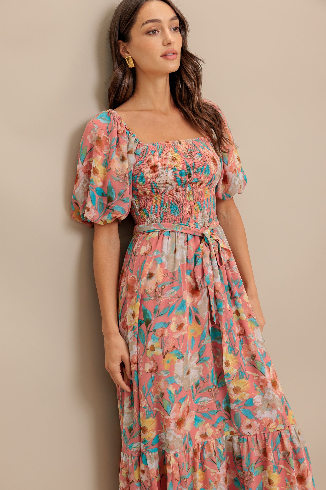 A printed woven midi dress featuring square neckline, short puff sleeve, smocked bodice, self sash tie and ruffled hemline