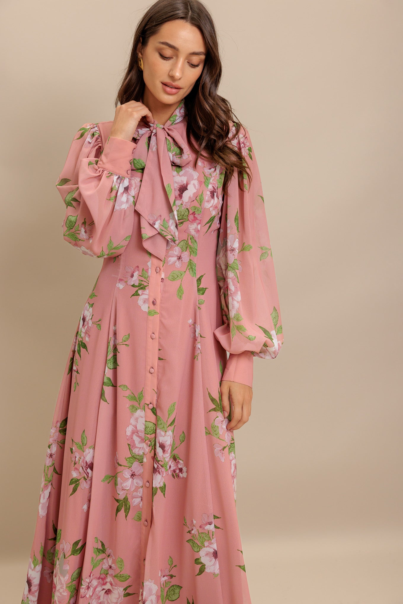 A printed woven midi dress featuring high neckline with bow tie, short puff sleeve with cuff, front button down and circle skirt