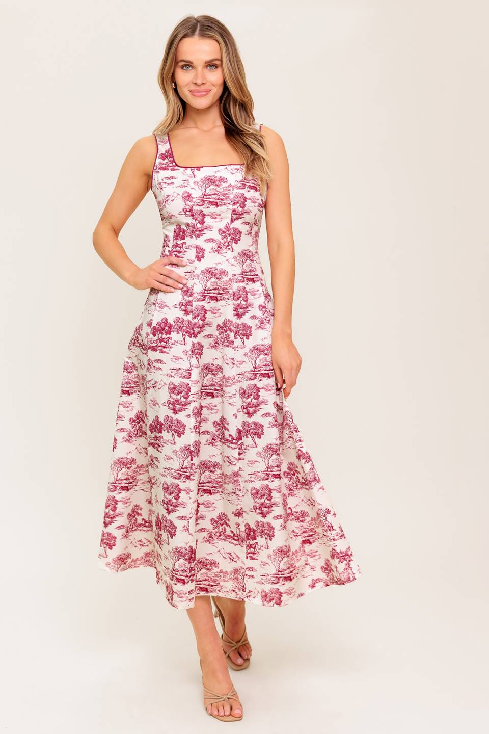 A printed woven midi dress featuring square neckline, sleeveless, circle skirt and back zipper closure.
