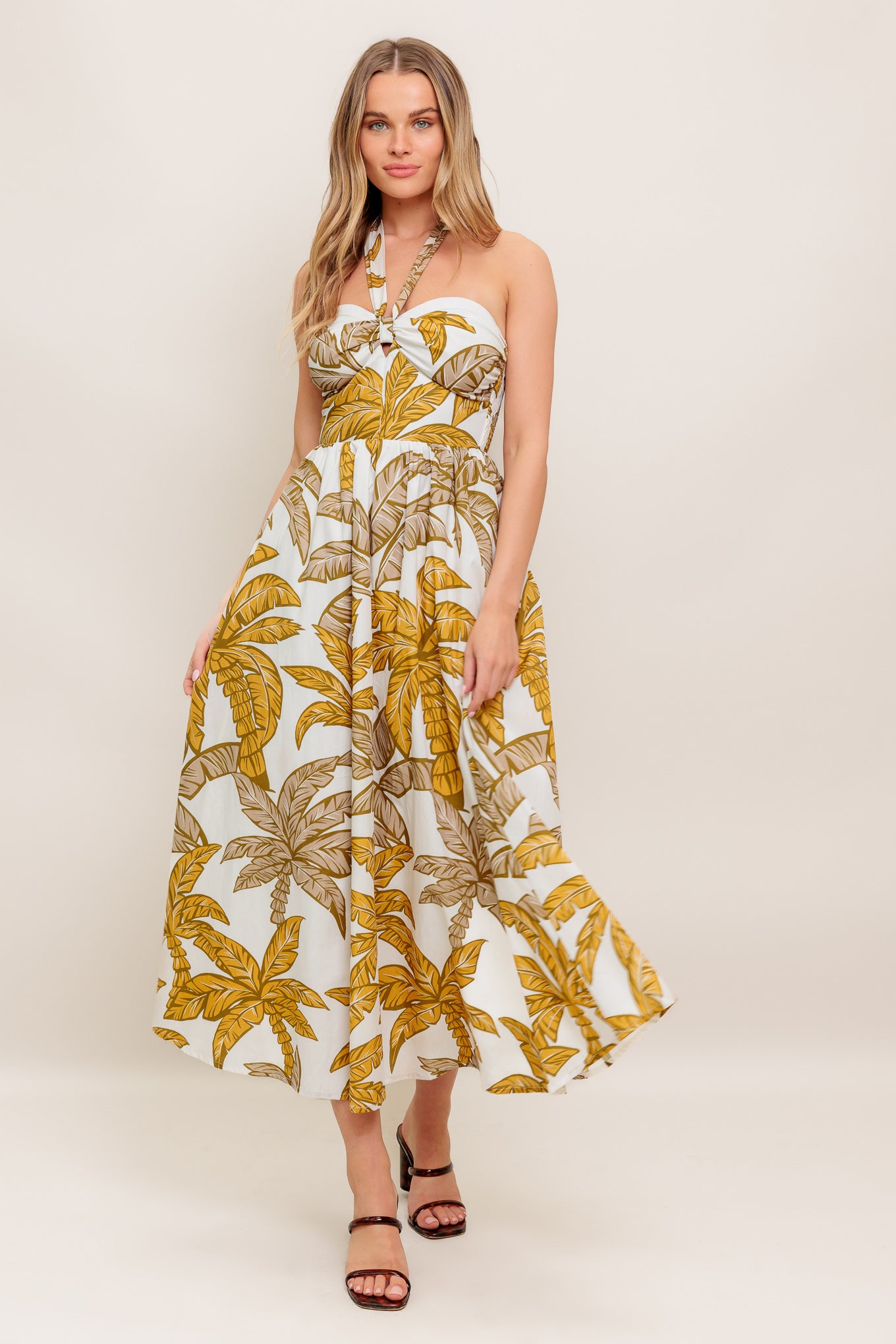 A printed woven midi dress featuring halter neckline with back neck tie, full skirt and smocked back bodice