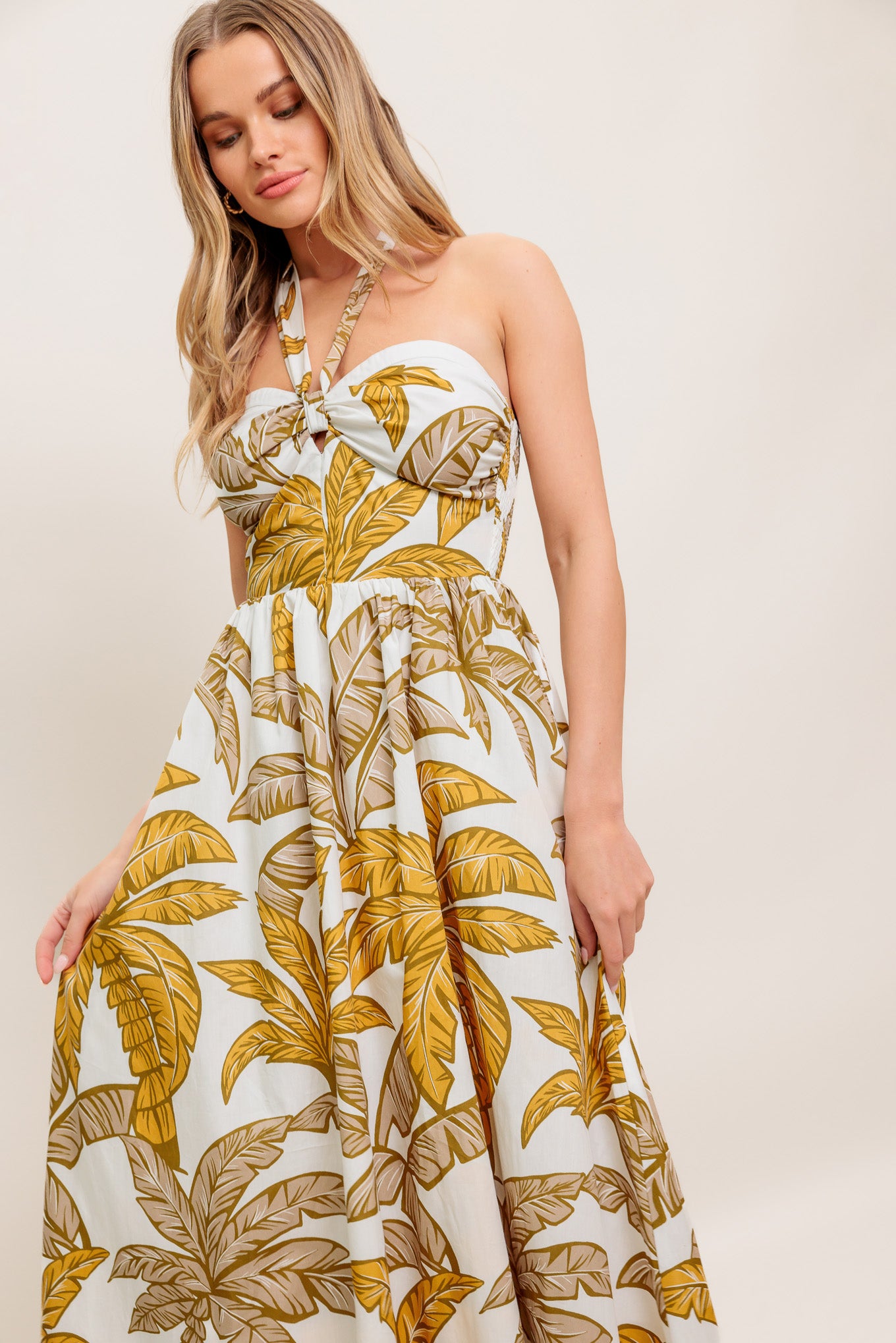 A printed woven midi dress featuring halter neckline with back neck tie, full skirt and smocked back bodice