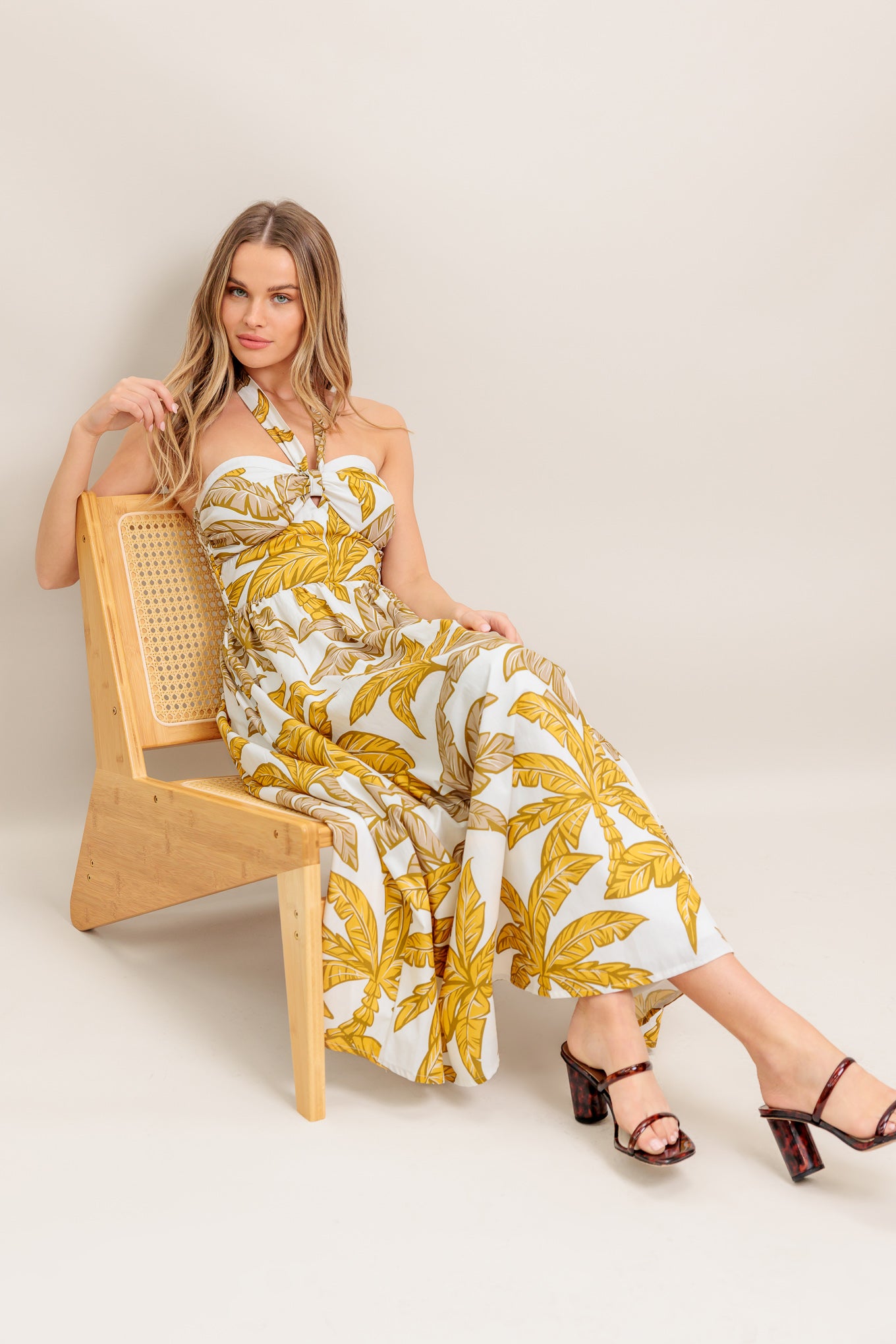 A printed woven midi dress featuring halter neckline with back neck tie, full skirt and smocked back bodice