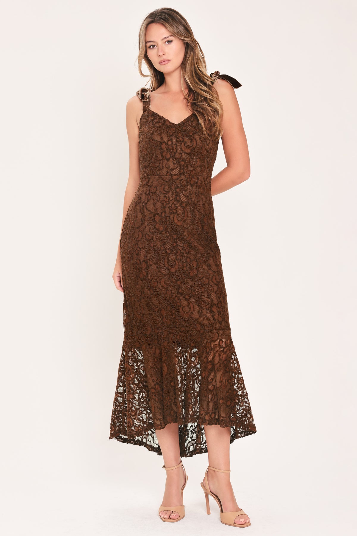 A woman modeling a sleeveless brown lace midi dress with shoulder tie details and a flared lace hem | Flying Tomato