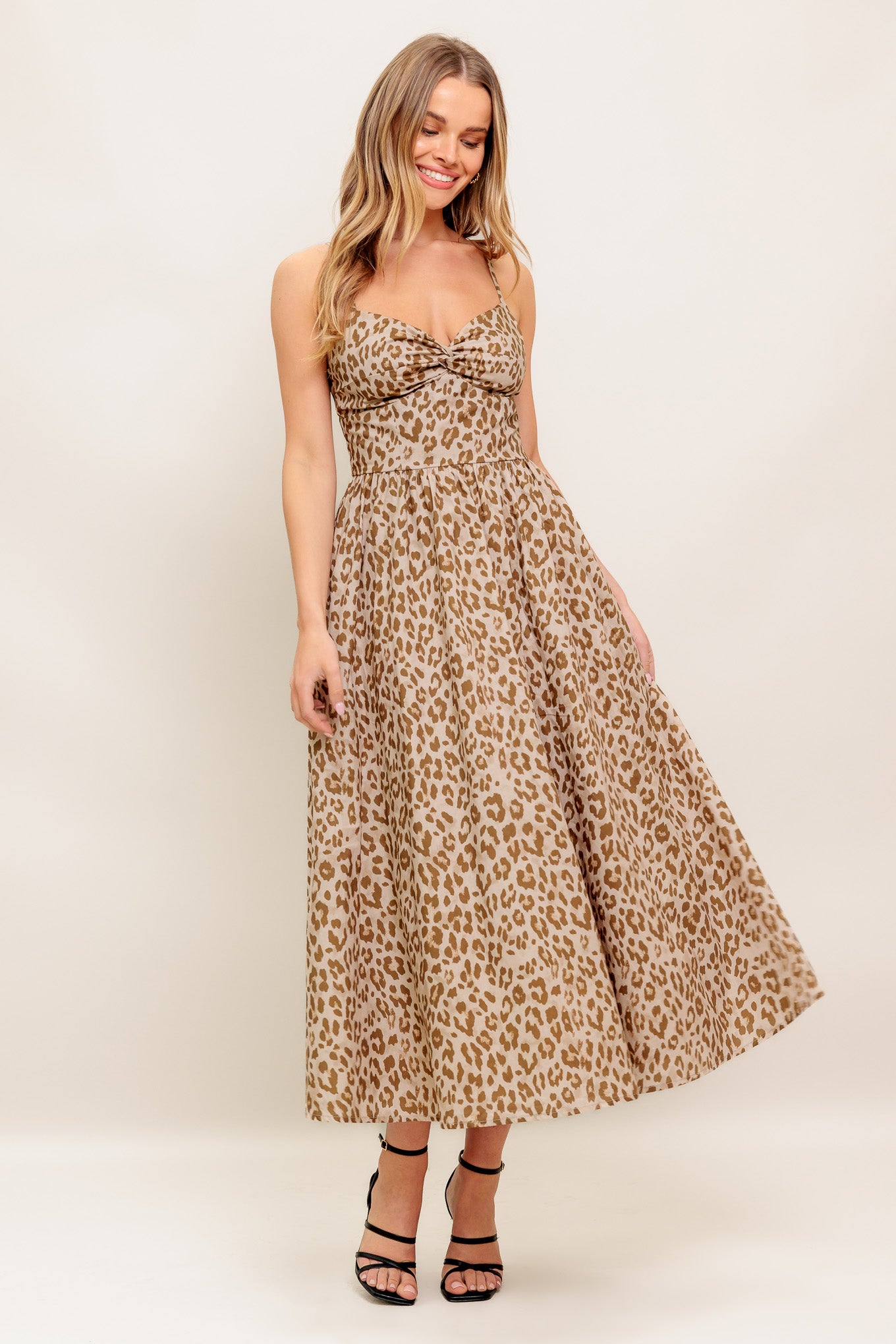 A printed woven midi dress featuring twisted cami bodice, straps, full skirt and smocked back with zipper closure