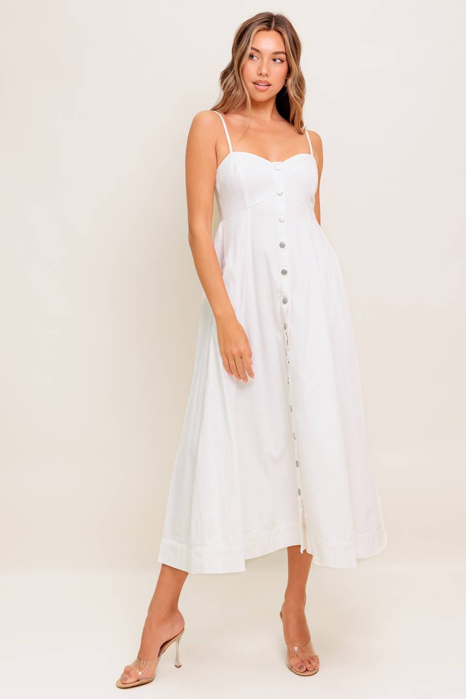 A solid woven midi dress featuring cami top, straps, front button down, full skirt and smocked back bodice