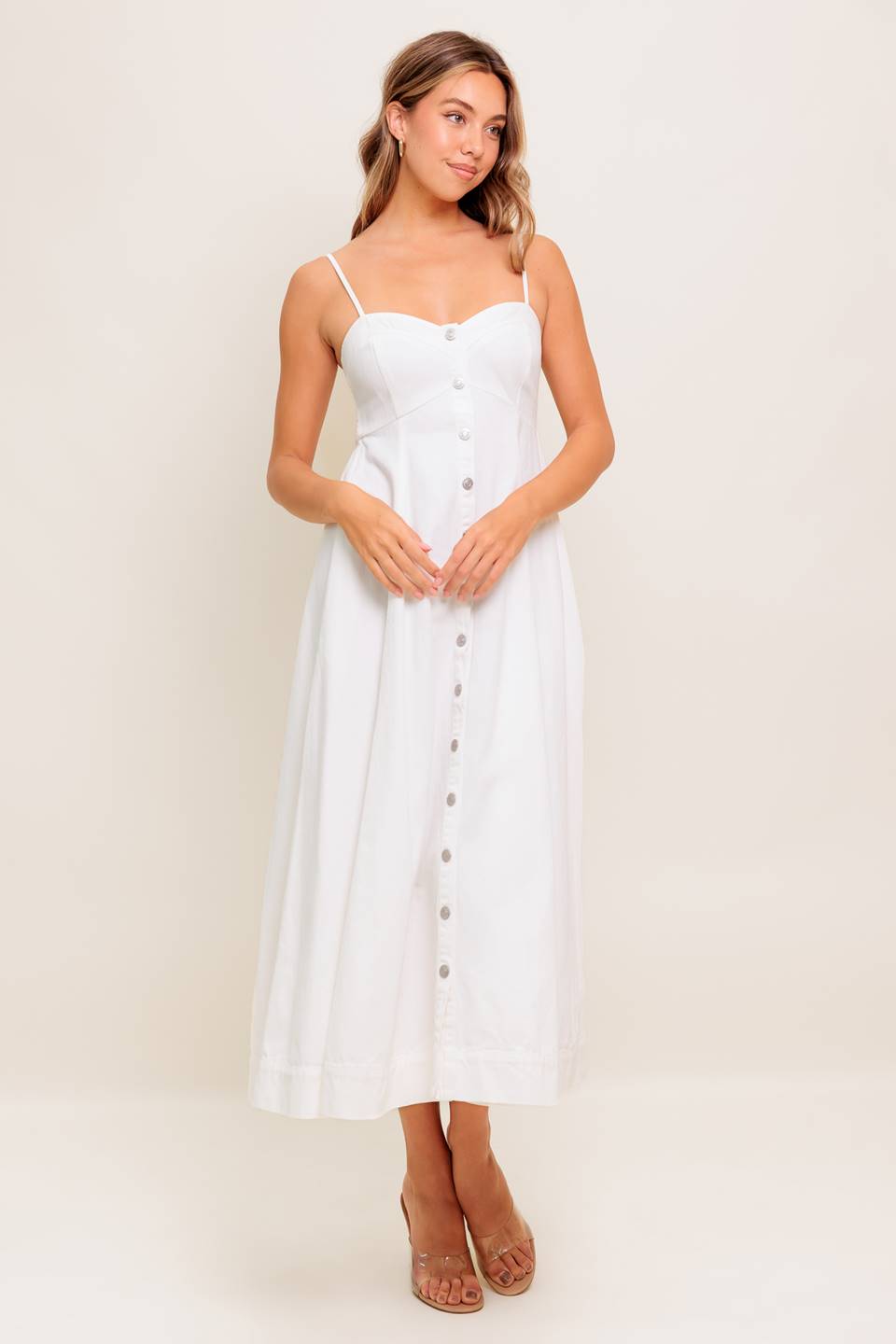 A solid woven midi dress featuring cami top, straps, front button down, full skirt and smocked back bodice