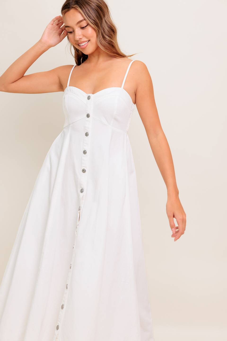 A solid woven midi dress featuring cami top, straps, front button down, full skirt and smocked back bodice