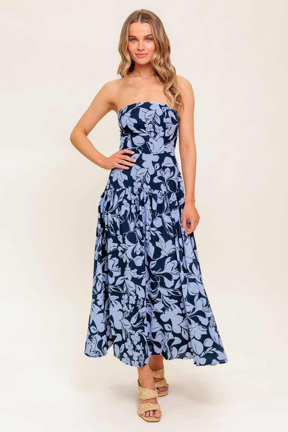 A printed woven midi dress featuring strapless, drop waist, full skirt and back zipper closure.