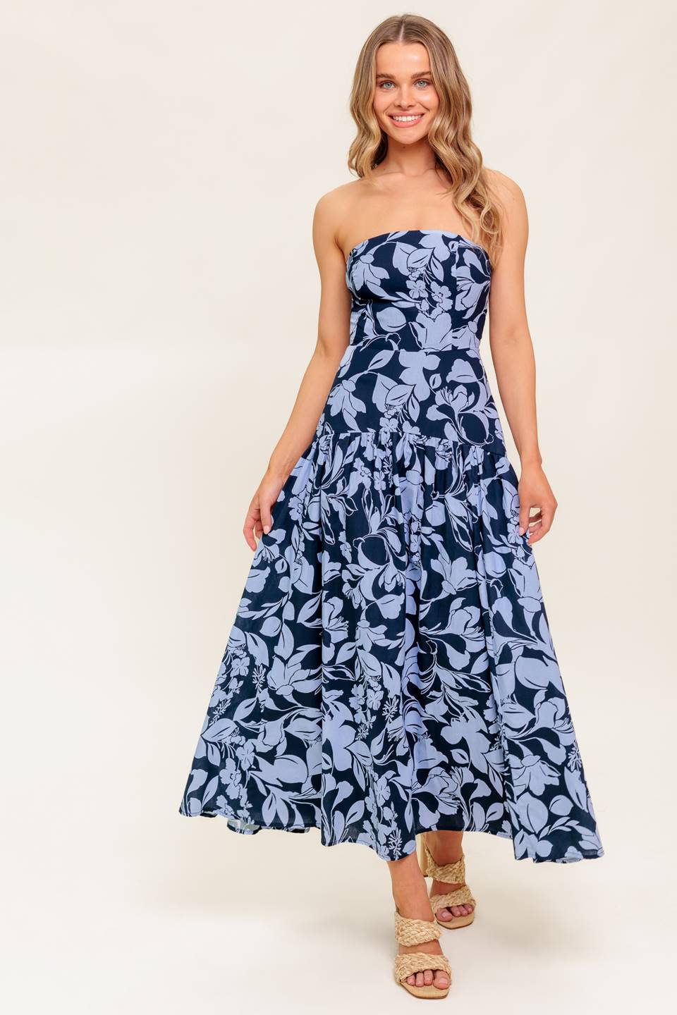 A printed woven midi dress featuring strapless, drop waist, full skirt and back zipper closure.