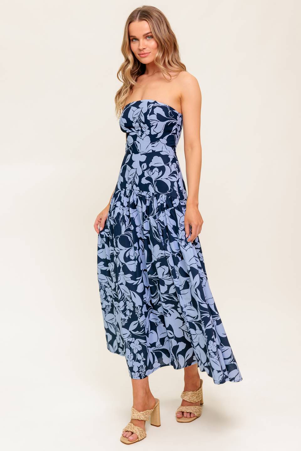A printed woven midi dress featuring strapless, drop waist, full skirt and back zipper closure.