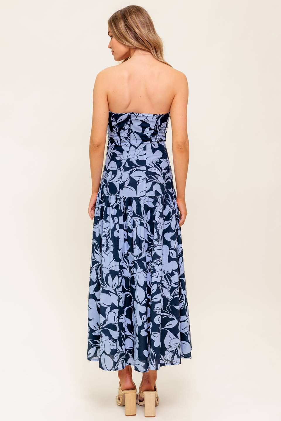 A printed woven midi dress featuring strapless, drop waist, full skirt and back zipper closure.