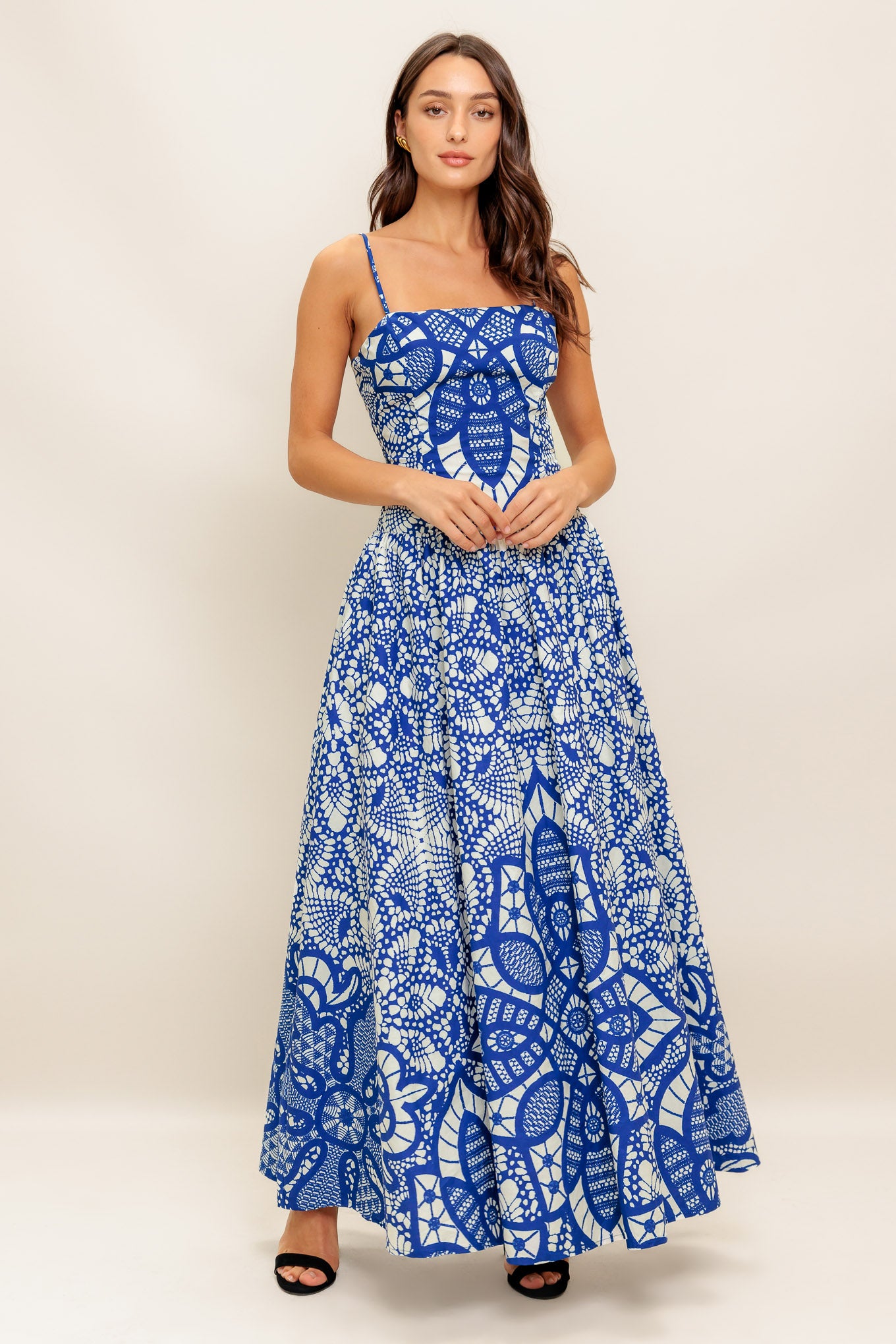 A printed woven ankle length dress featuring straight neckline, straps, drop waist and back zipper closure