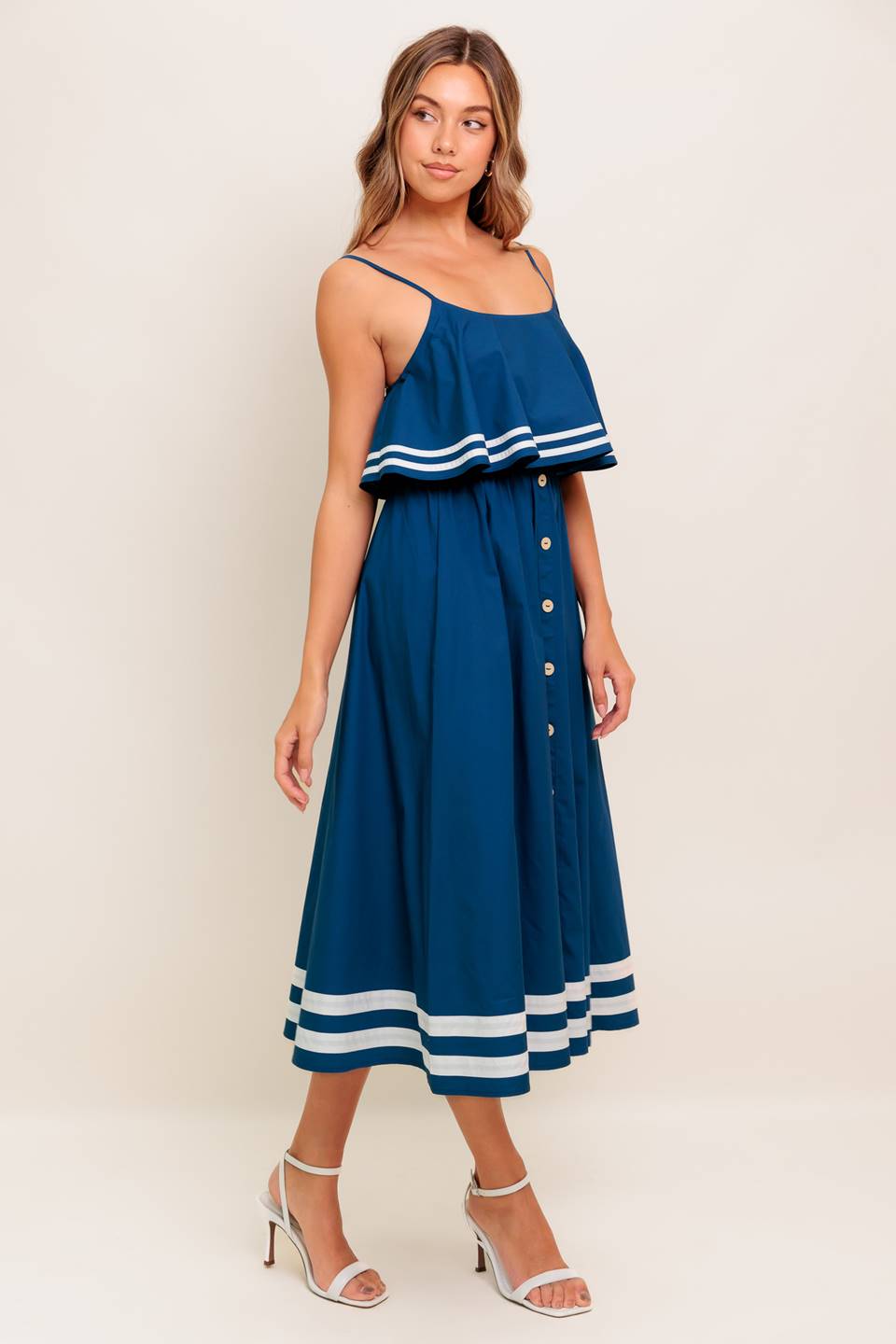 A solid navy woven midi dress featuring U neckline, straps, pop over, and button down skirt