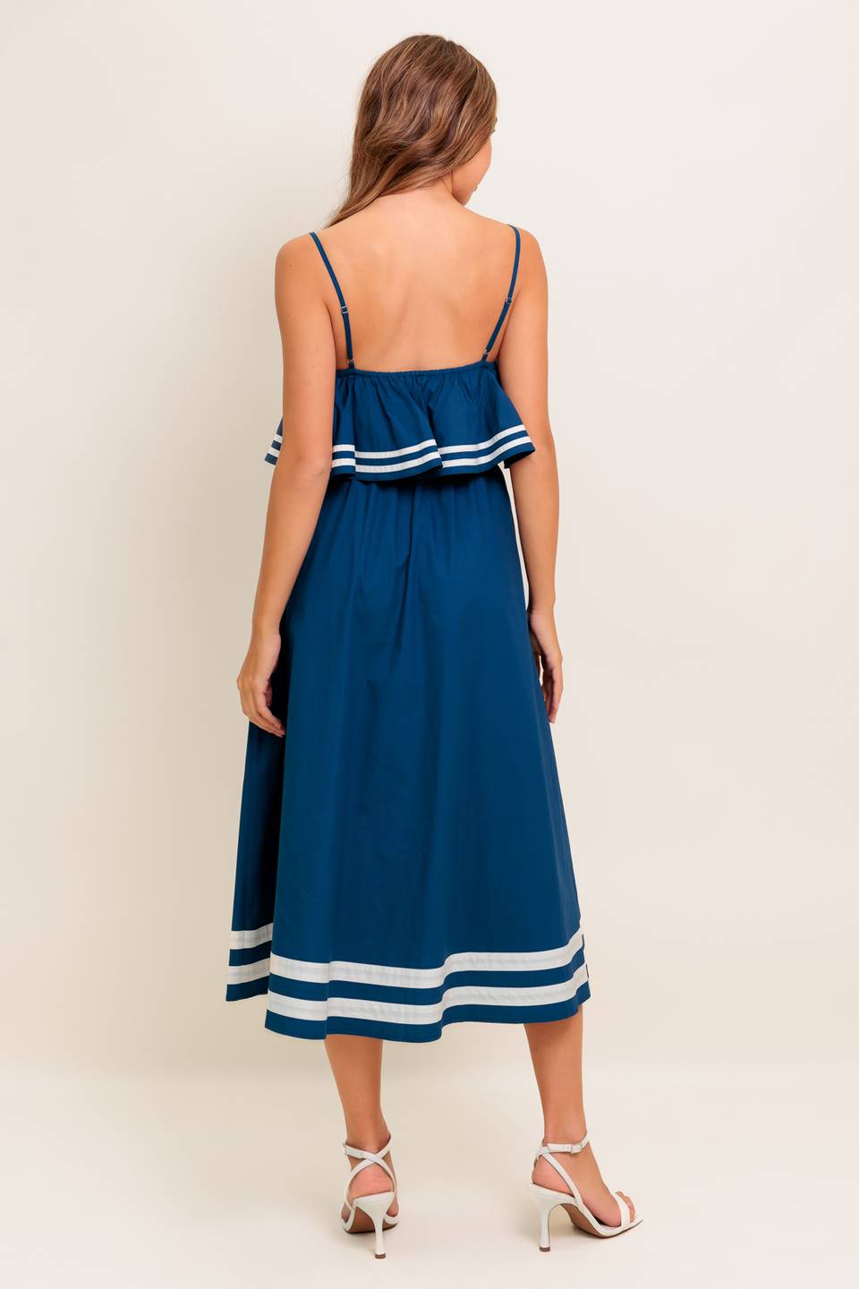 A solid navy woven midi dress featuring U neckline, straps, pop over, and button down skirt