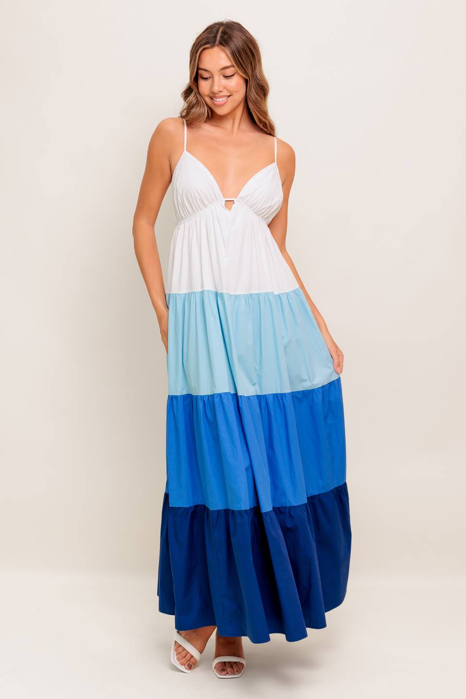A color blocked woven maxi dress featuring cami top with straps, tiered skirt and back tie closure