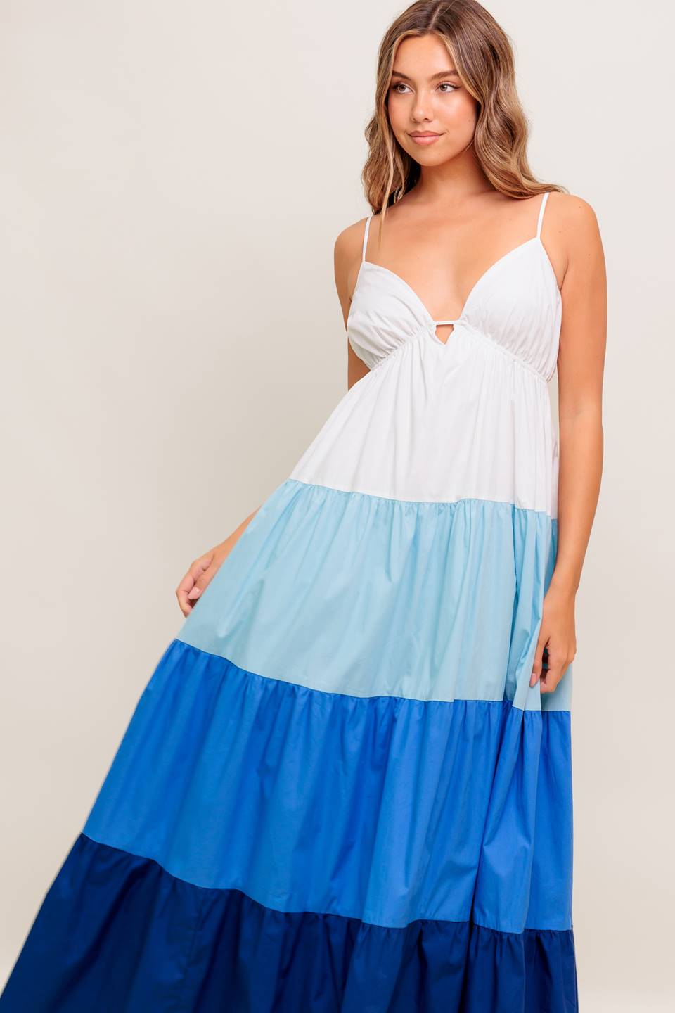 A color blocked woven maxi dress featuring cami top with straps, tiered skirt and back tie closure