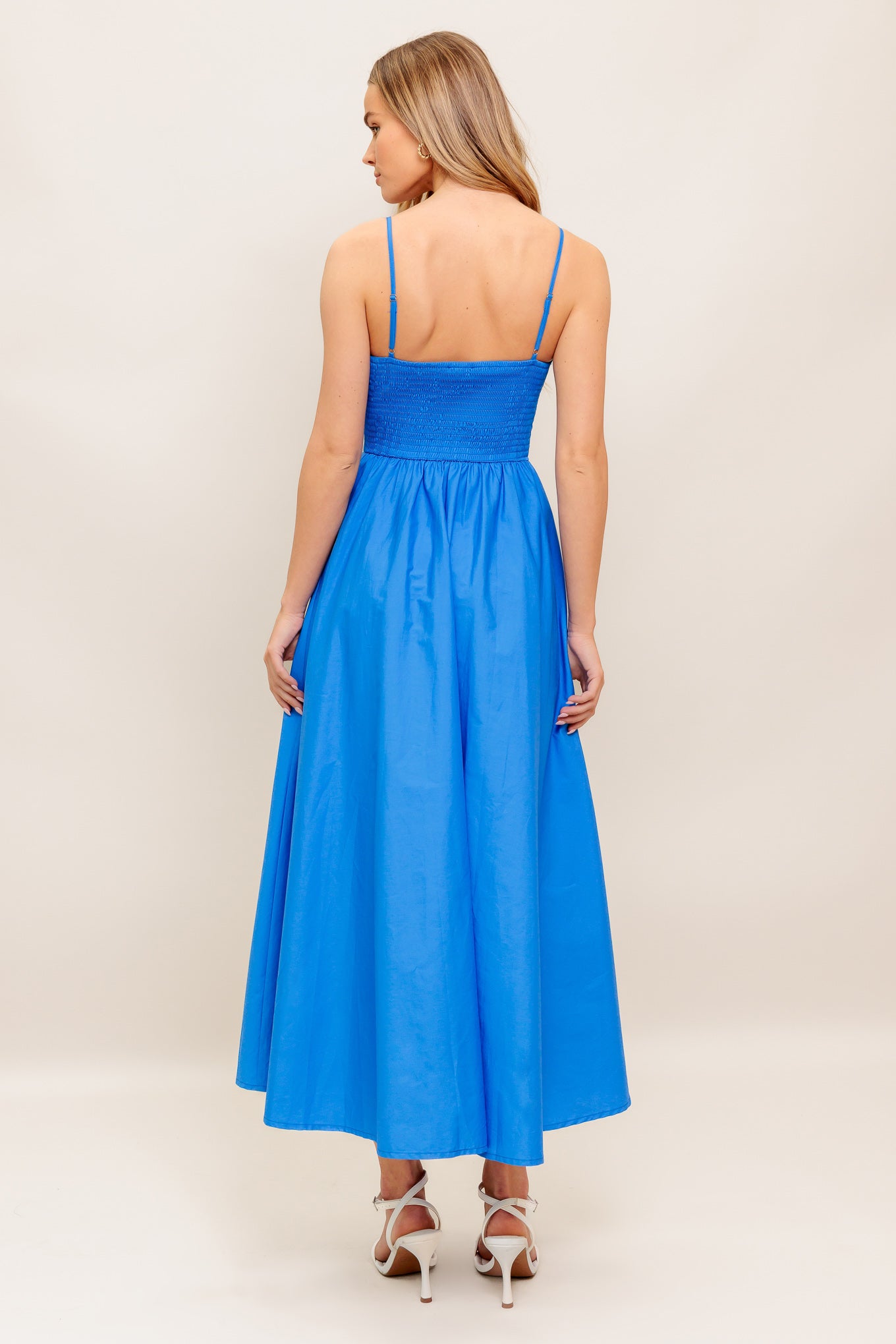 A solid woven midi dress featuring sweetheart neckline, straps, basque waist, full skirt and smocked back bodice