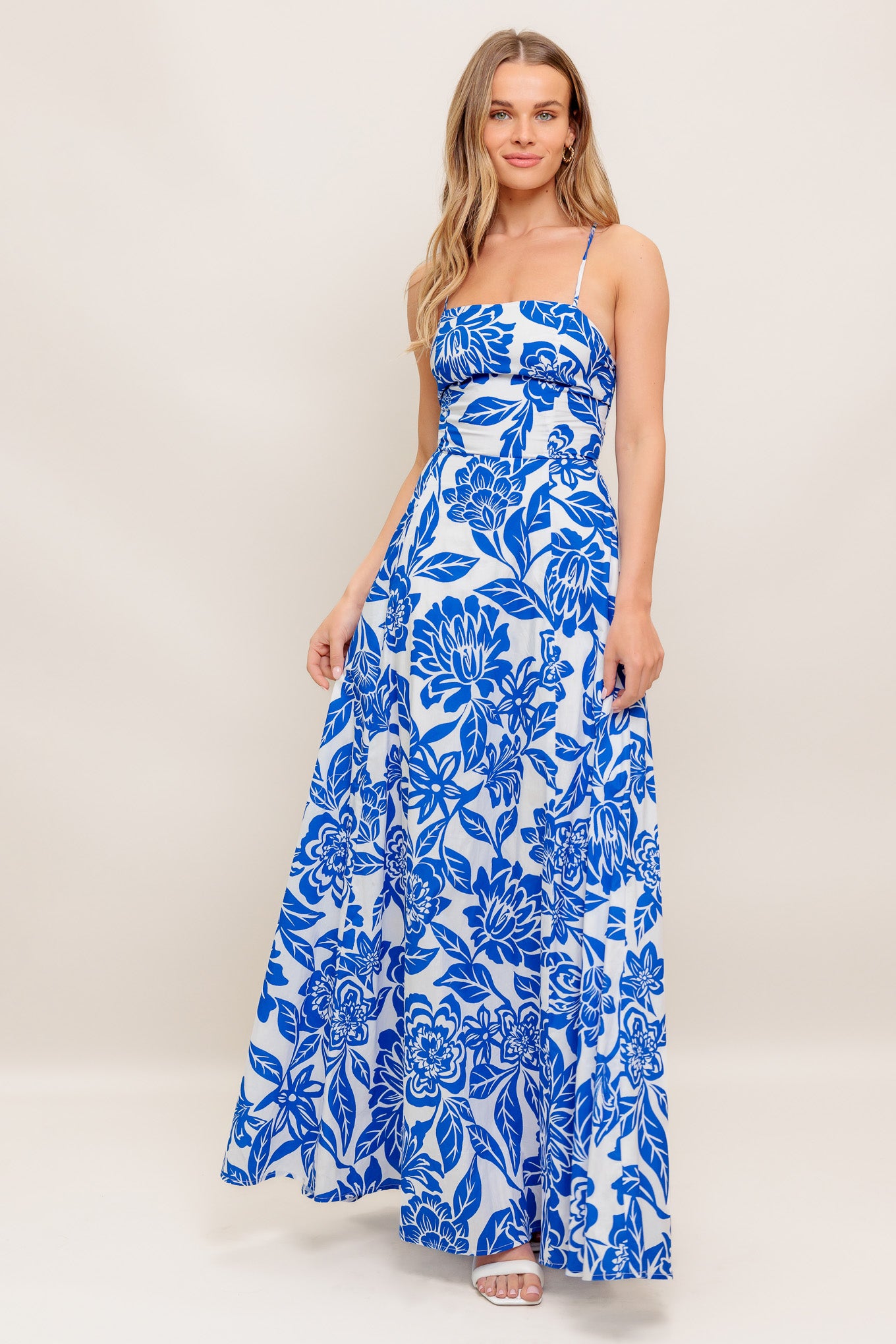 A printed woven ankle dress featuring straight neckline, circle skirt, bare back with cross straps