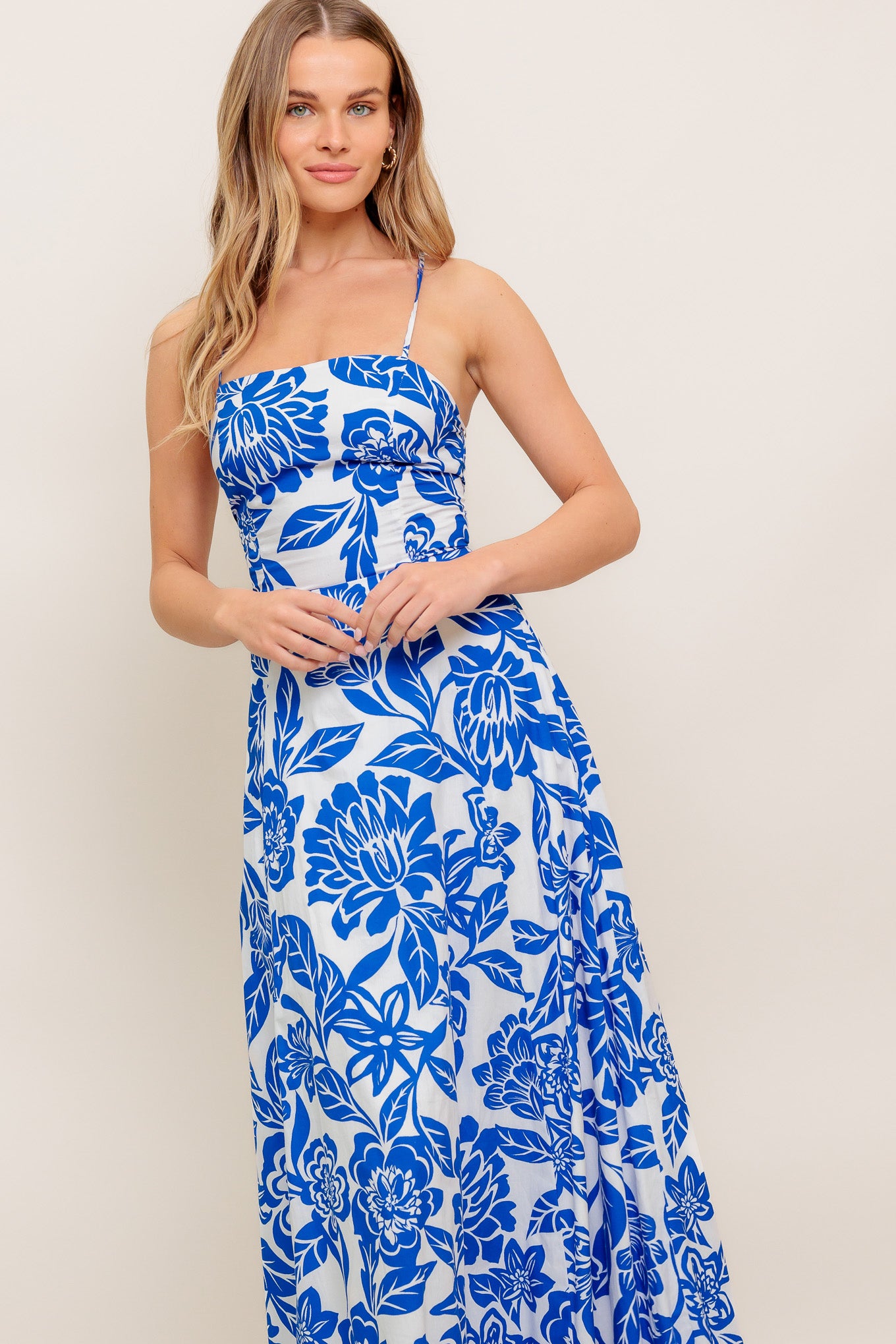 A printed woven ankle dress featuring straight neckline, circle skirt, bare back with cross straps