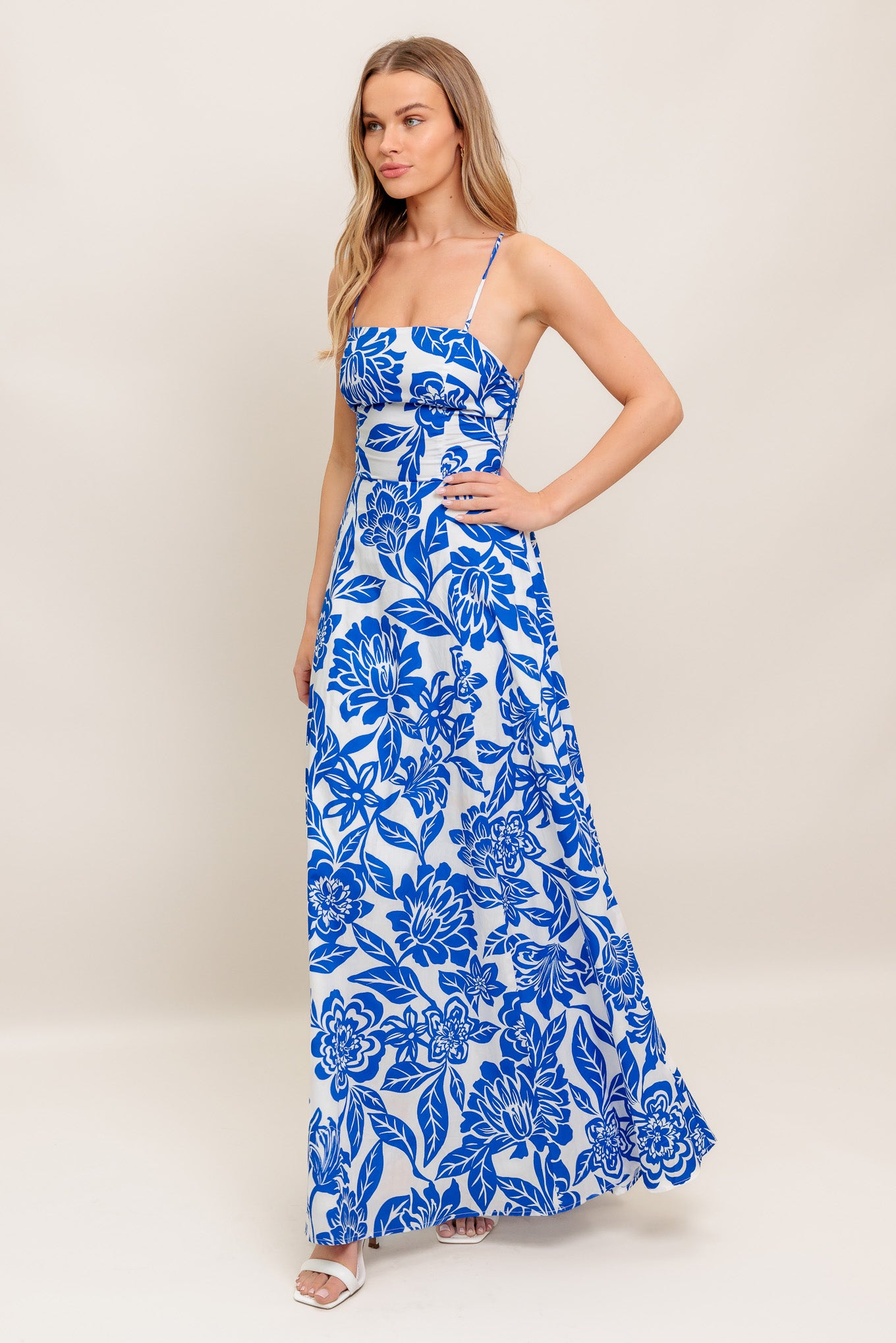 A printed woven ankle dress featuring straight neckline, circle skirt, bare back with cross straps