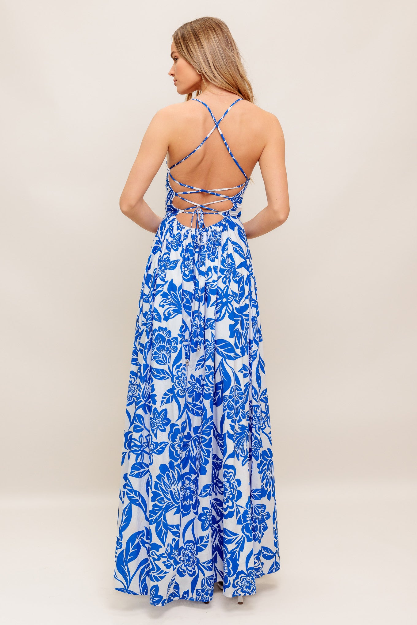 A printed woven ankle dress featuring straight neckline, circle skirt, bare back with cross straps