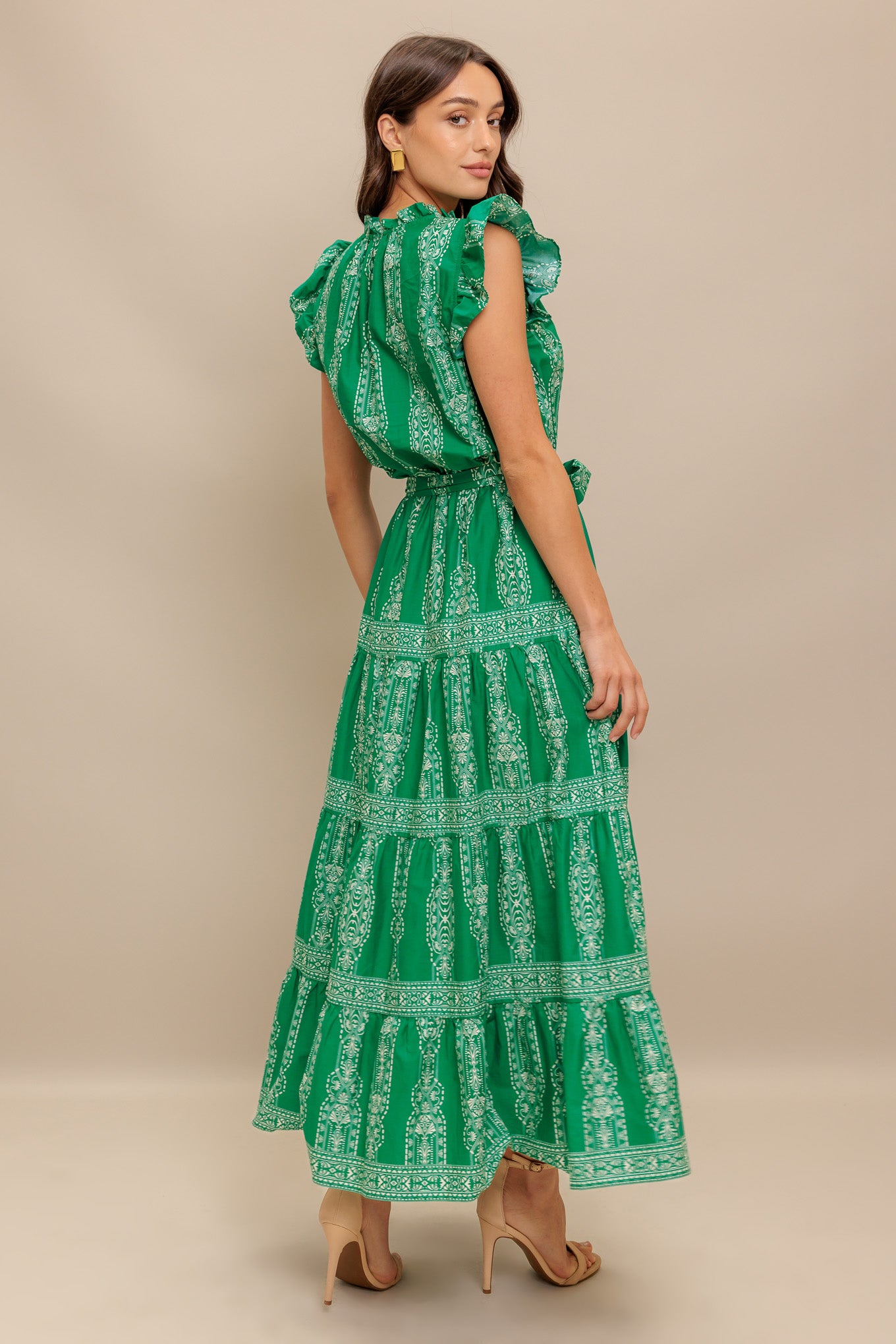A printed woven midi dress featuring ruffled neckline with V center, short ruffle sleeve, elasticized waist with self sash tie and tiered skirt