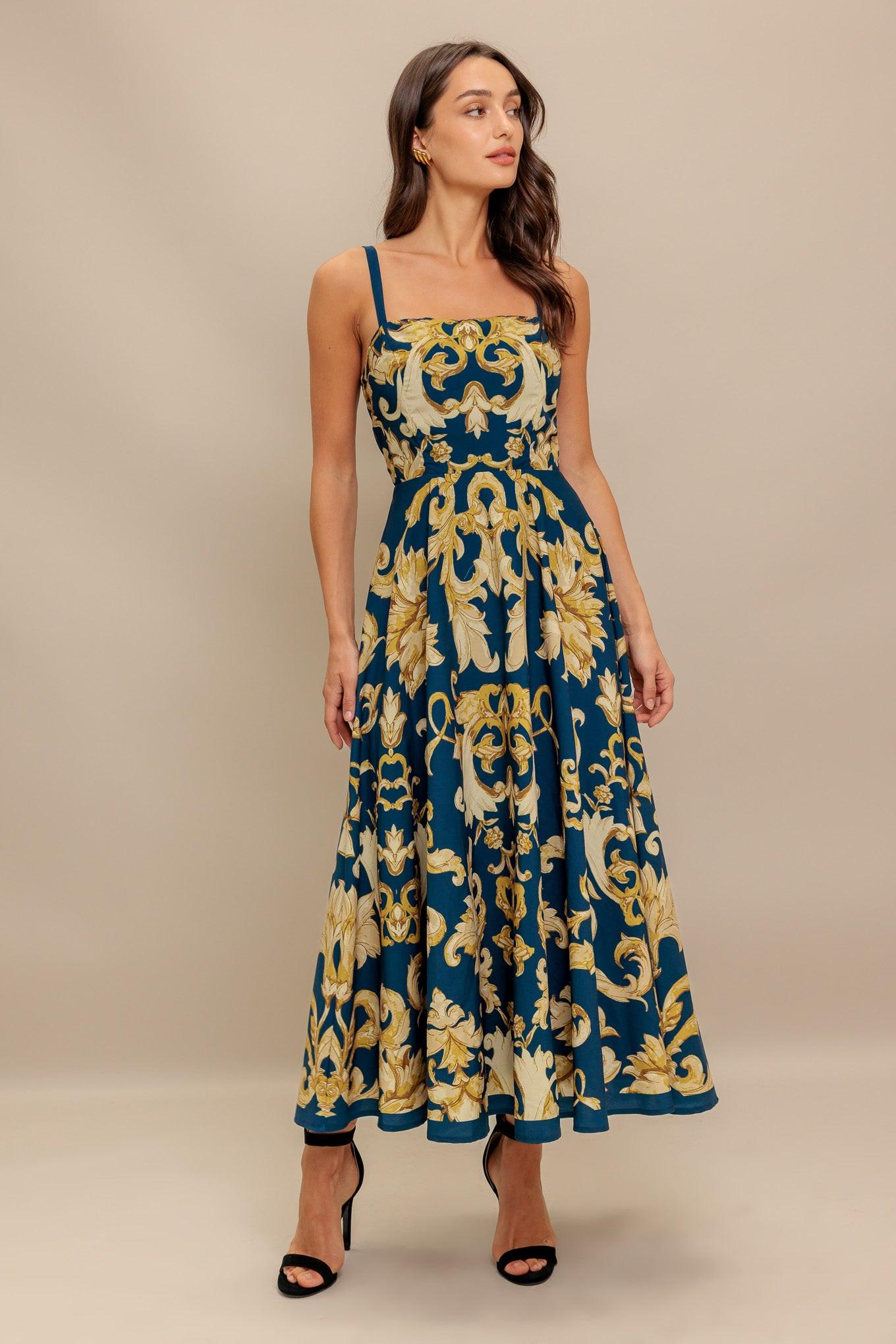 A printed woven midi dress featuring straight neckline, straps, circle skirt and back zipper closure
