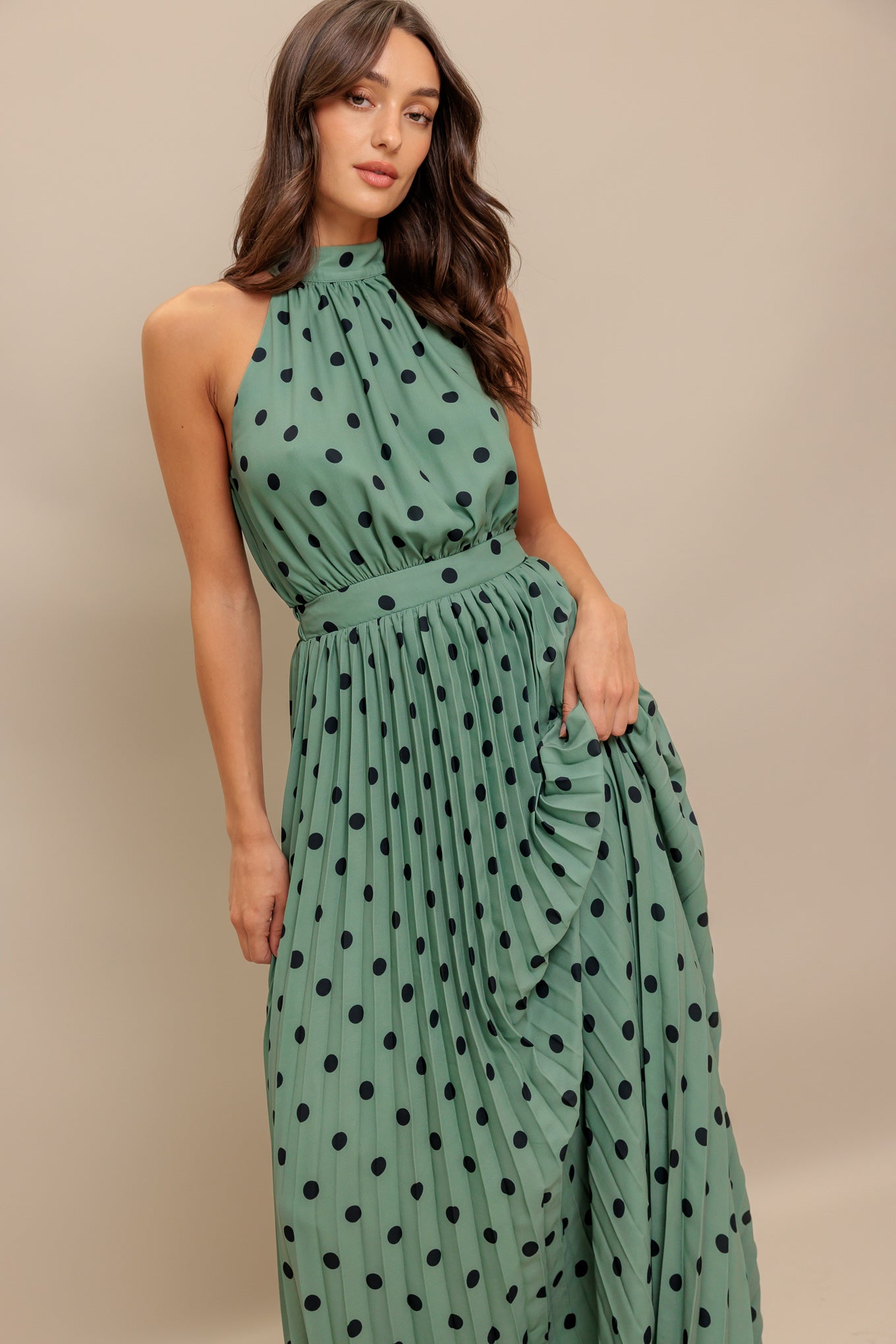 A printed woven maxi dress featuring halter neckline with back bow tie, sleeveless, pleated skirt and elasticized back waistband
