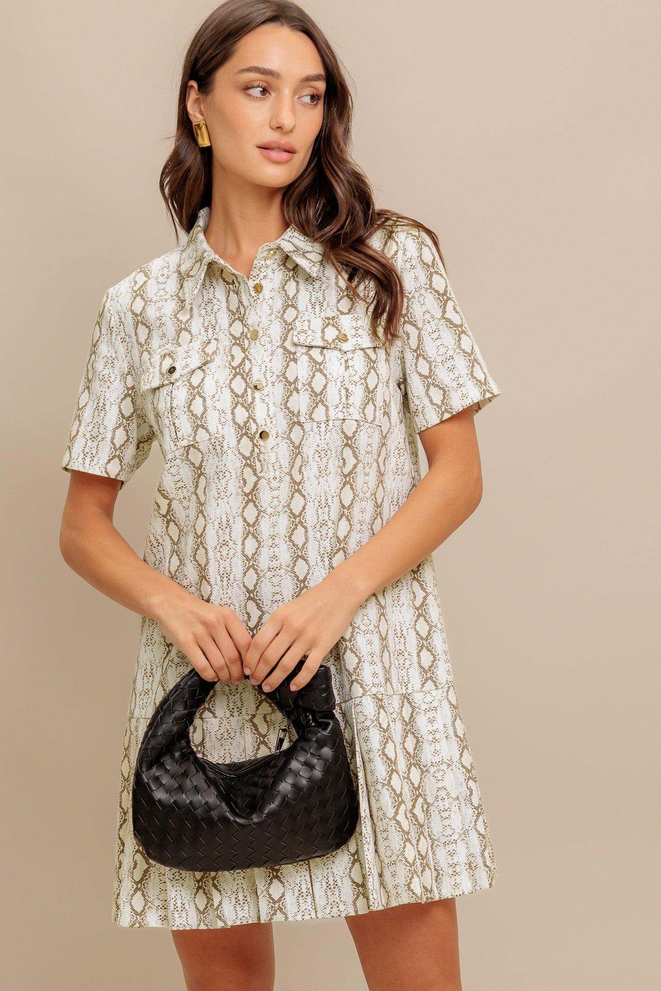 A printed woven mini dress featuring collar, short sleeve, pocket, button down and pleated bottom