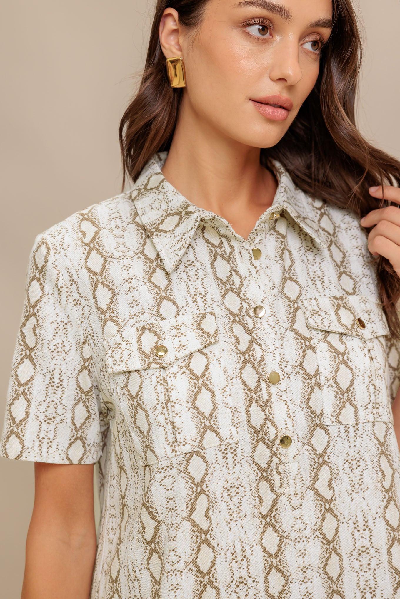 A printed woven mini dress featuring collar, short sleeve, pocket, button down and pleated bottom