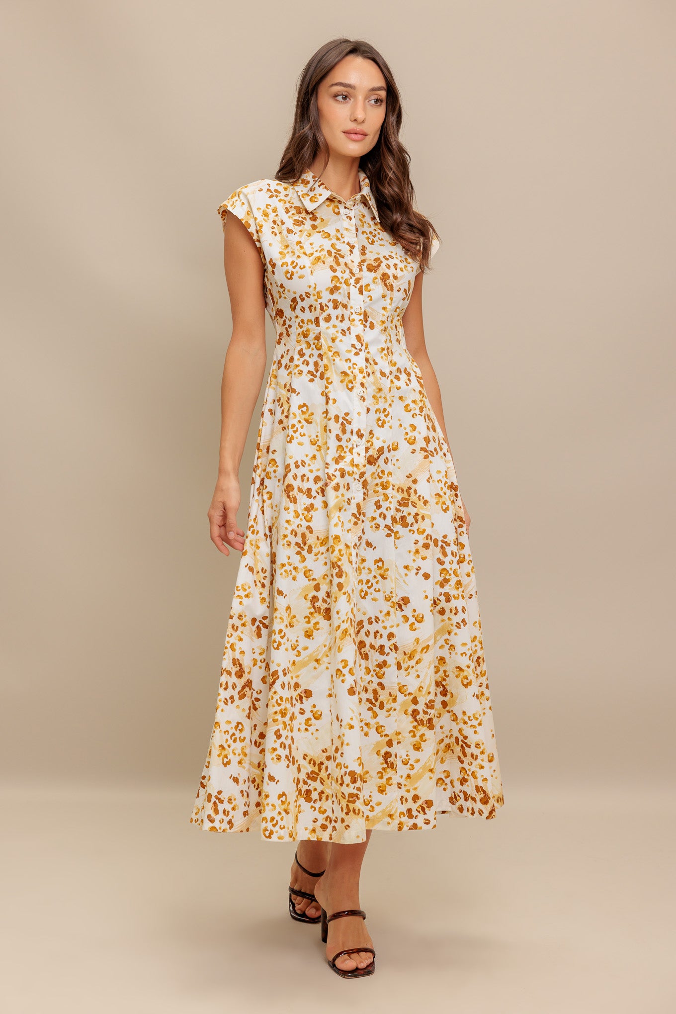 A printed woven midi dress featuring collar, short sleeve, front button down and circle skirt