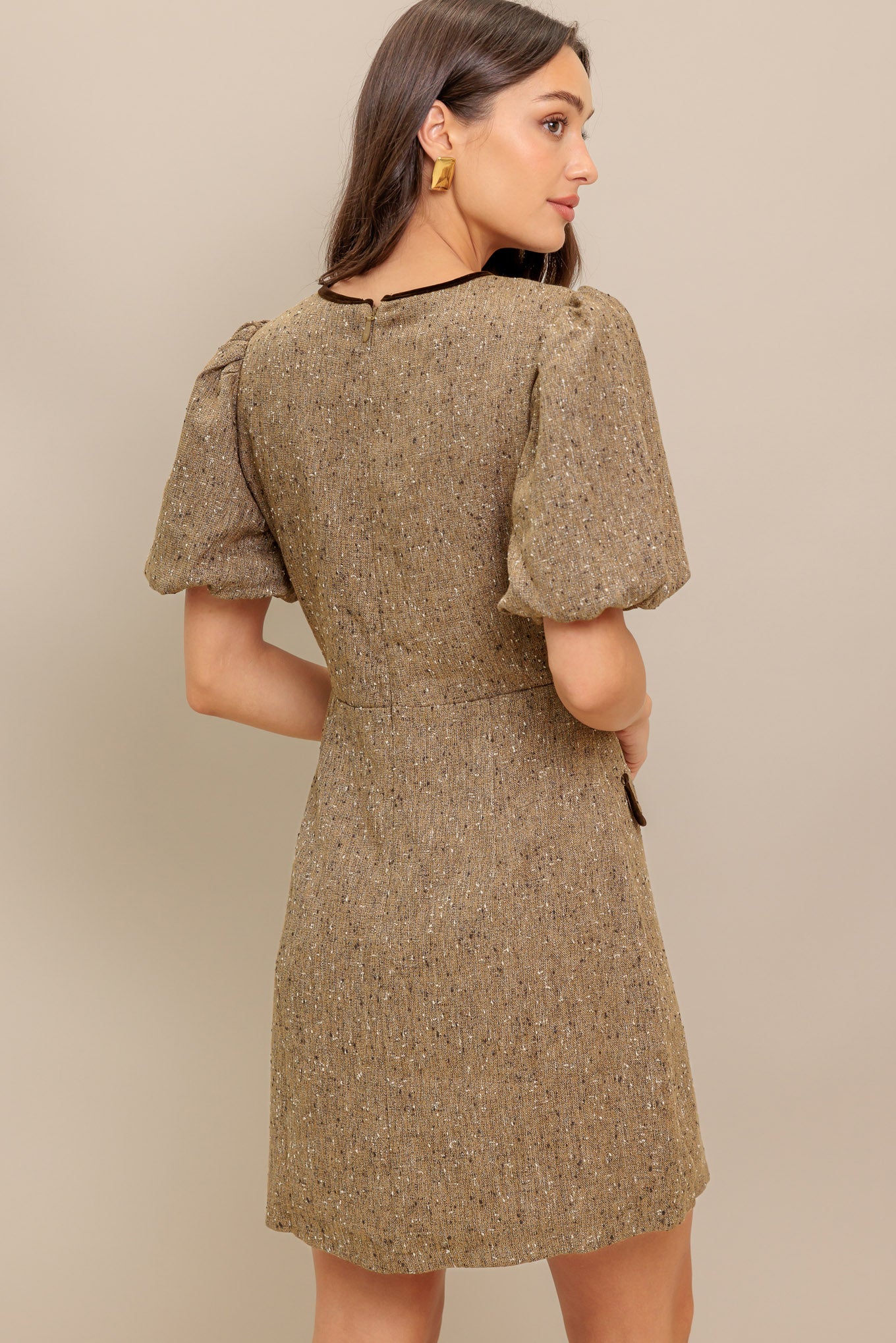 A woven tweed mini dress featuring round neckline, front double bow tie, short puff sleeve, faux pockets and back zipper closure