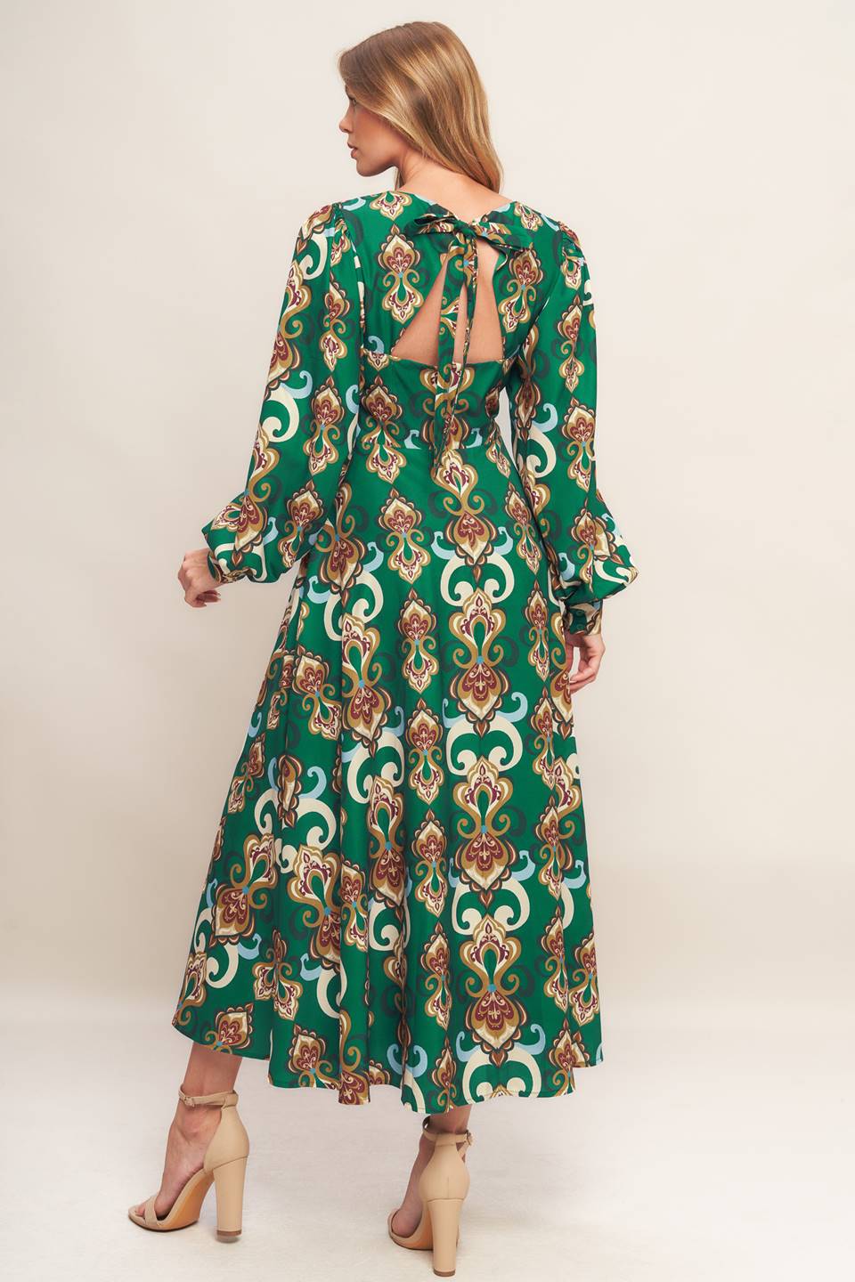 A printed woven midi dress featuring round neckline, long sleeve with cuff, circle skirt, back cut out with tie and zipper closure