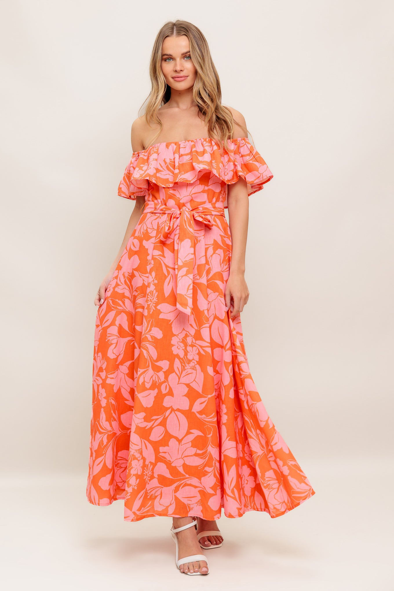 A printed woven midi dress featuring off shoulder neckline with flounce, self sash tie, circle skirt and back zipper closure