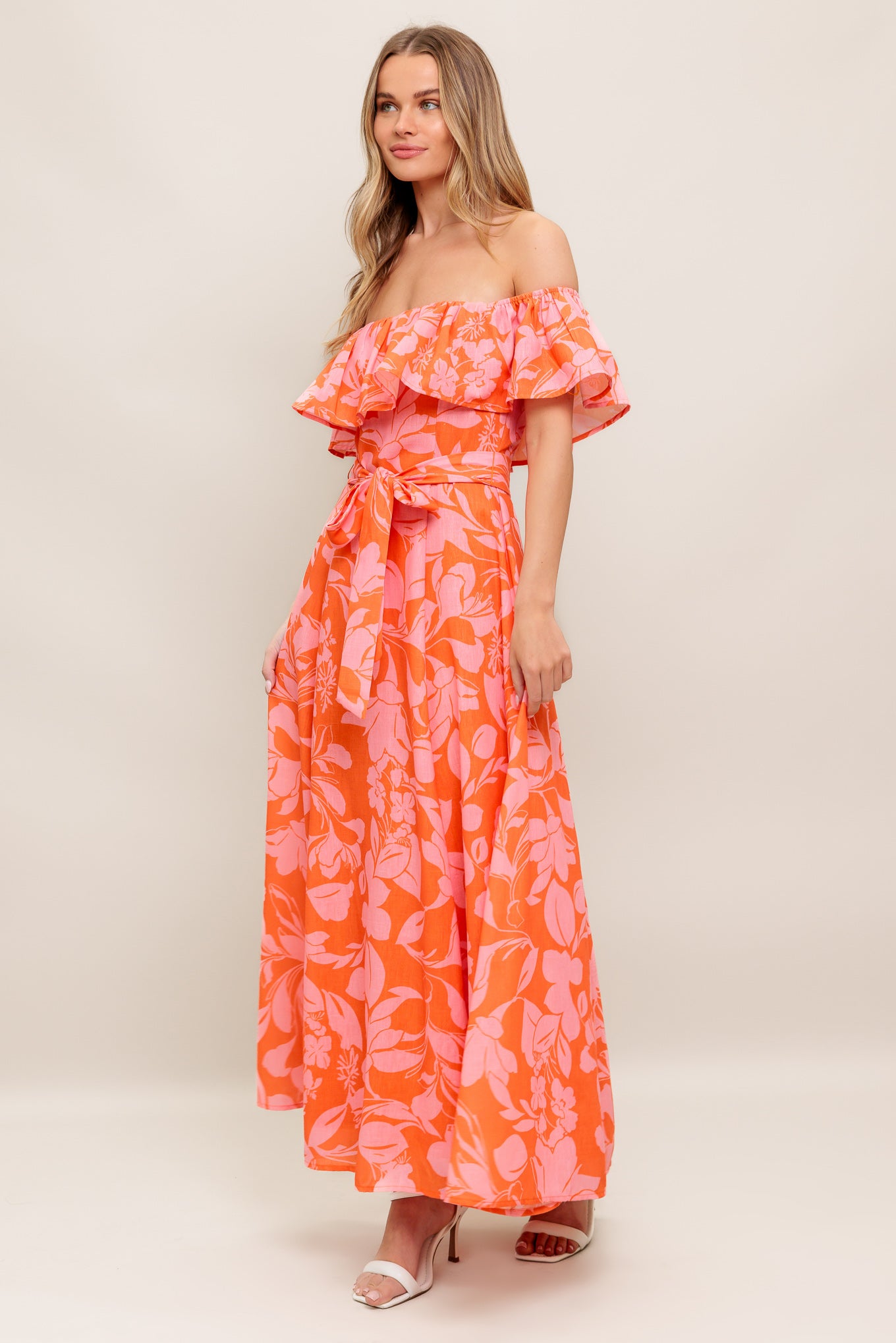 A printed woven midi dress featuring off shoulder neckline with flounce, self sash tie, circle skirt and back zipper closure