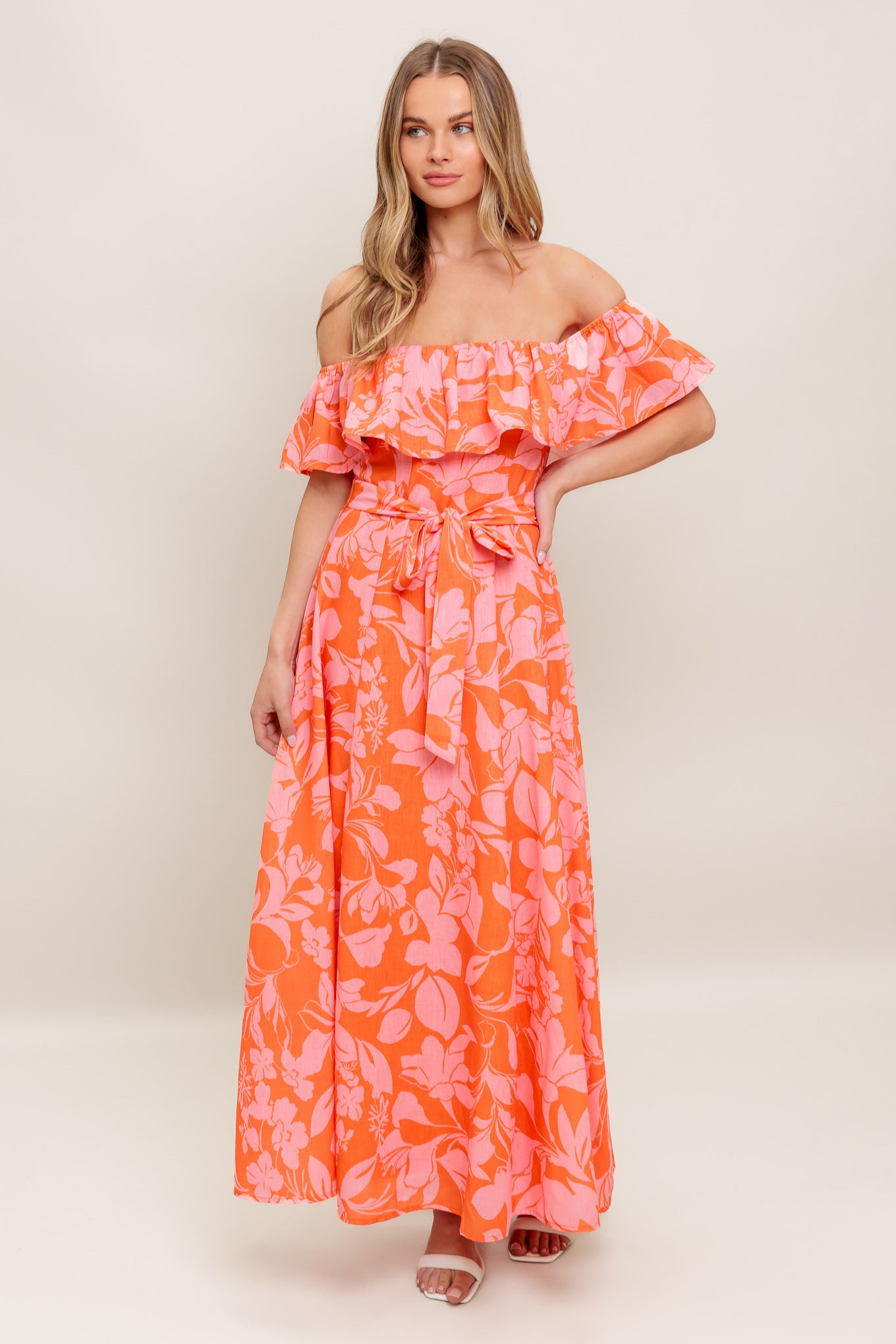 A printed woven midi dress featuring off shoulder neckline with flounce, self sash tie, circle skirt and back zipper closure