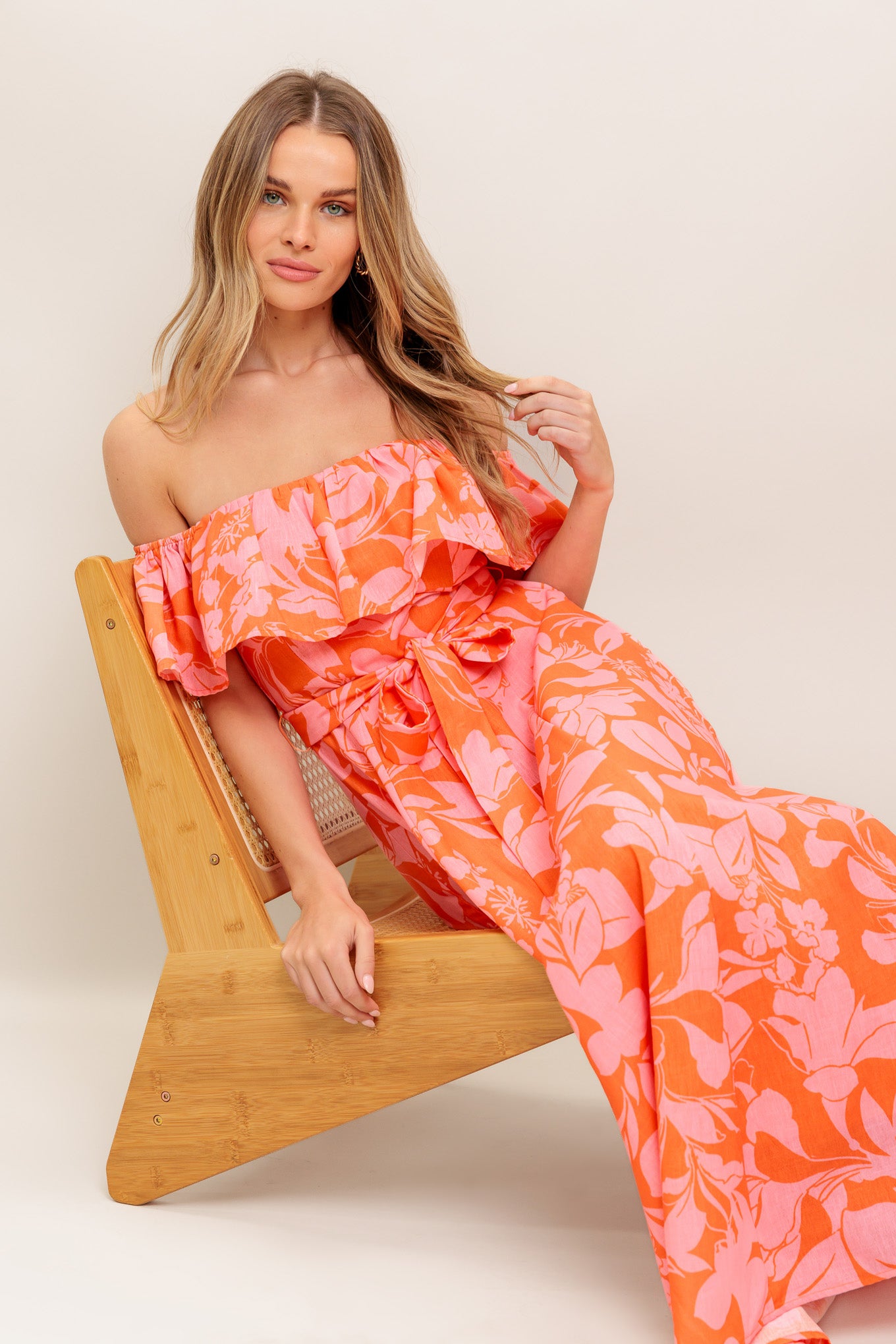 A printed woven midi dress featuring off shoulder neckline with flounce, self sash tie, circle skirt and back zipper closure