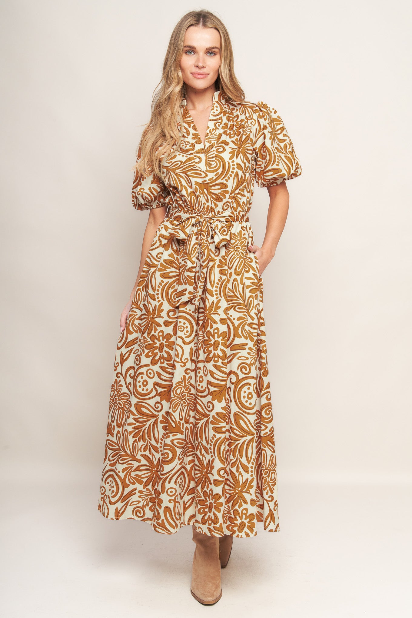 A printed woven midi dress featuring high neckline with center front V, short puff sleeve and elasticized waist with self sash tie