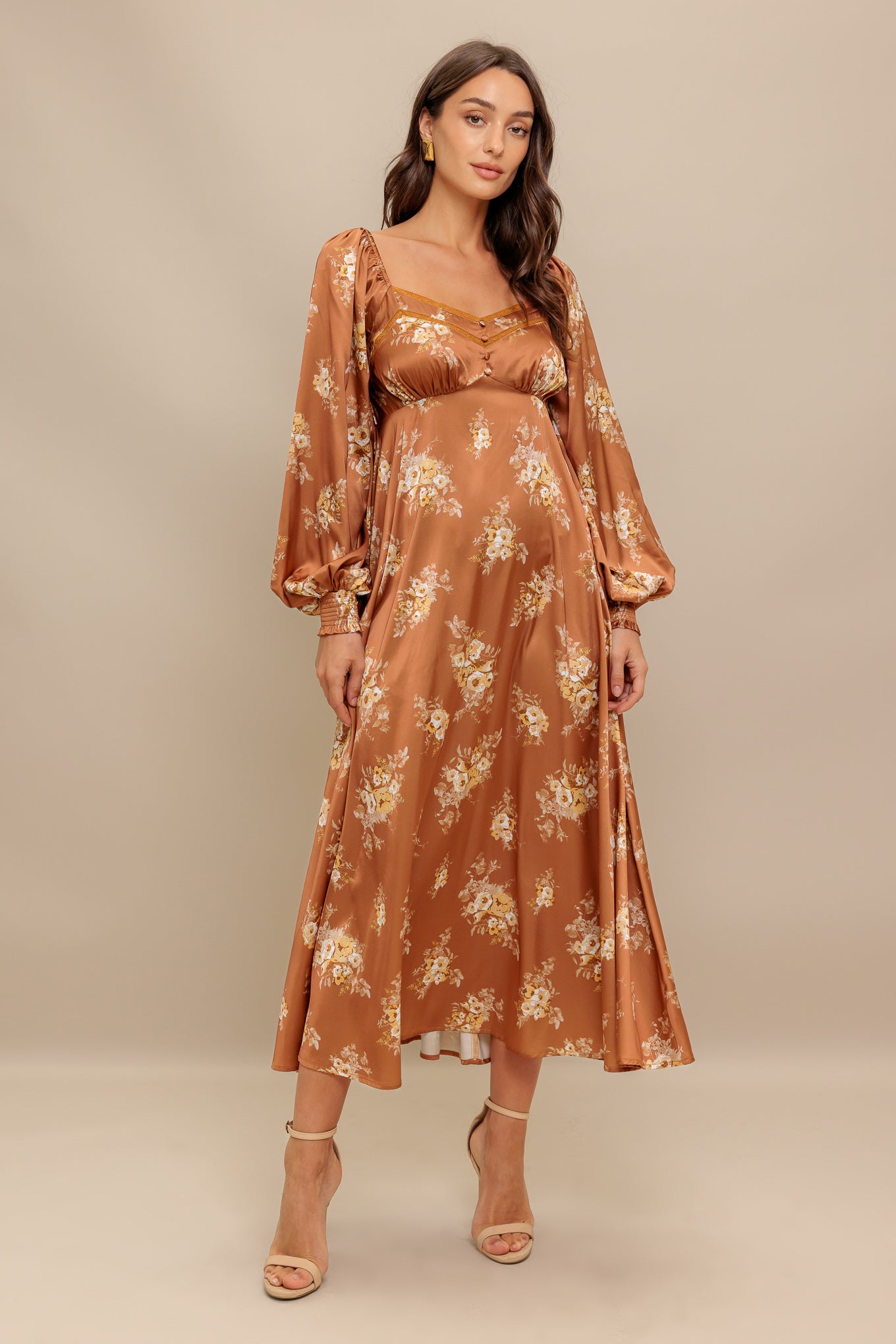 A printed woven midi dress featuring sweetheart neckline, long sleeve with smocked cuff, empire waistline, circle skirt and smocked back bodice