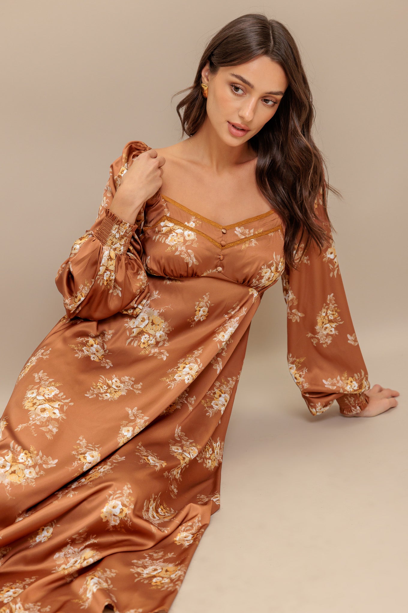 A printed woven midi dress featuring sweetheart neckline, long sleeve with smocked cuff, empire waistline, circle skirt and smocked back bodice