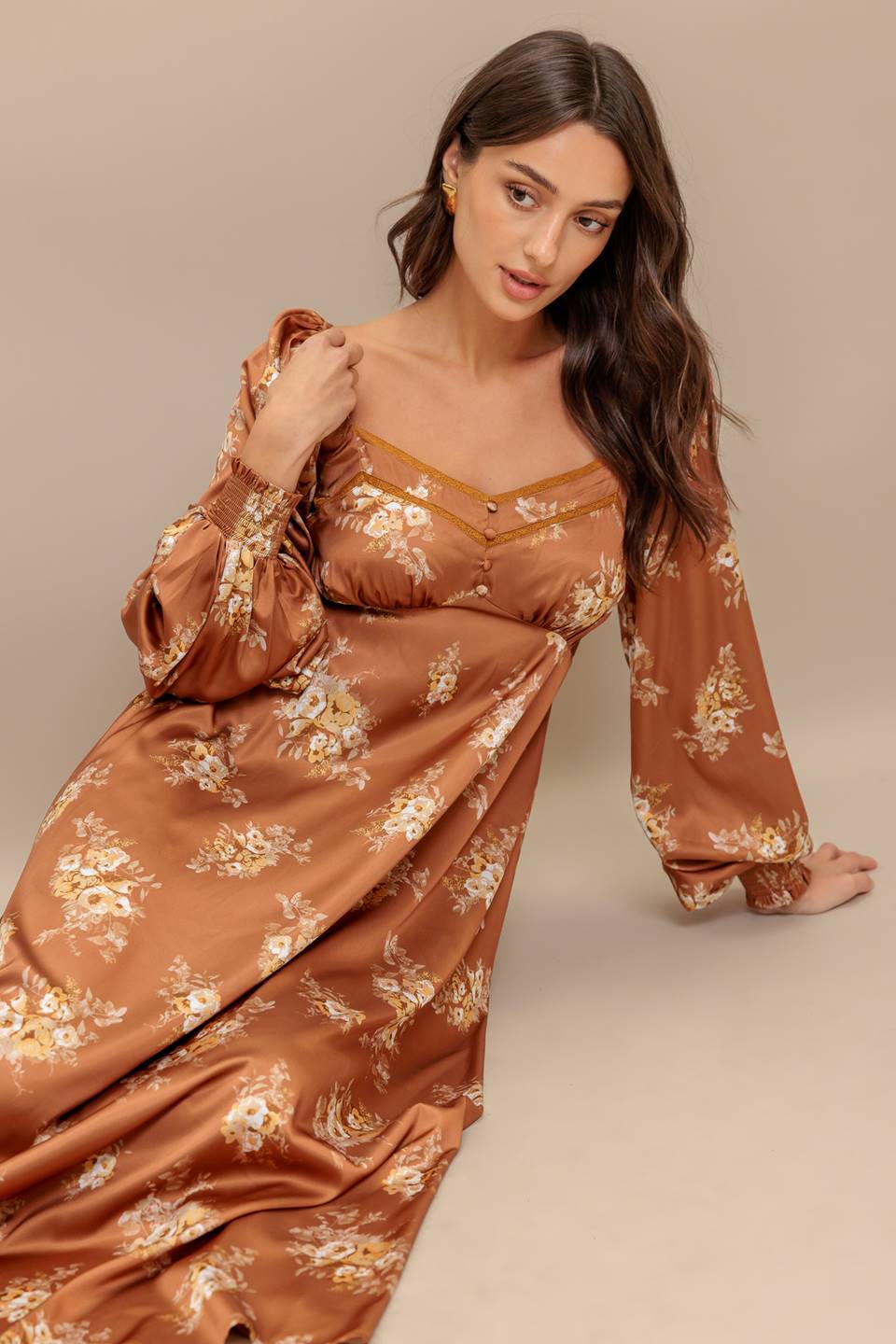 Woman wearing a long sleeve with smocked cuff bronze midi dress with floral print featuring sweetheart neckline, empire waistline, circle skirt and smocked back bodice | Flying Tomato