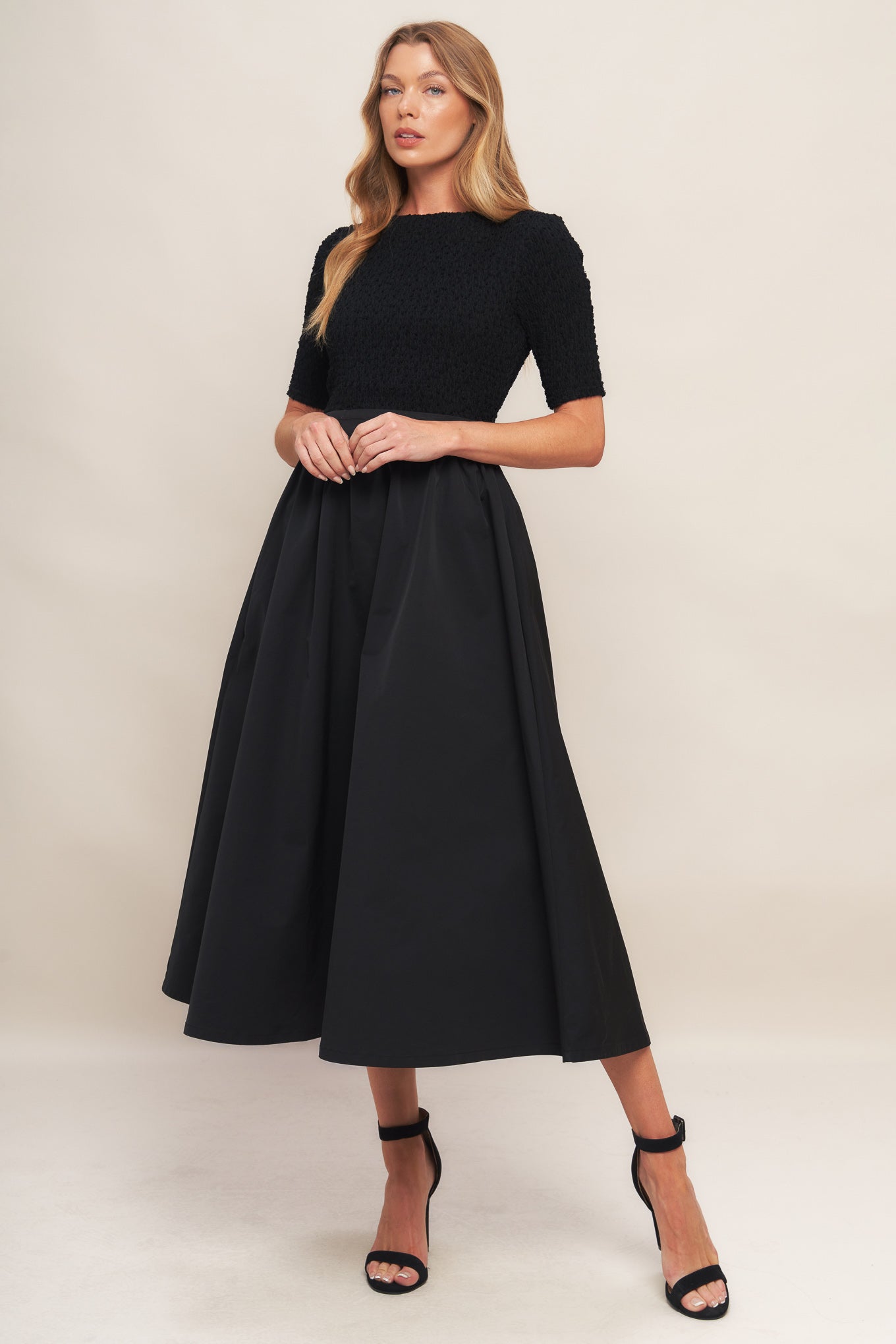 A solid woven midi dress featuring textured woven top with round neckline and short sleeve, full woven skirt and back zipper closure