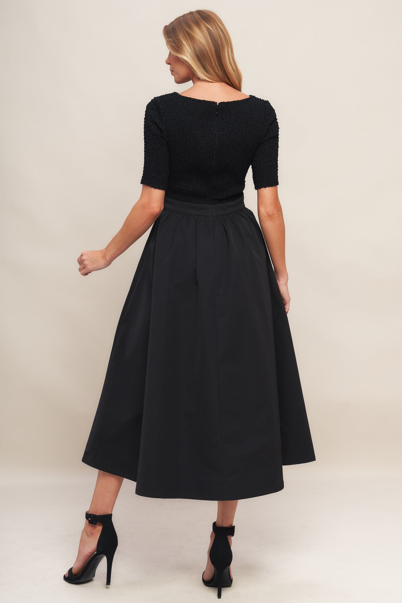 A solid woven midi dress featuring textured woven top with round neckline and short sleeve, full woven skirt and back zipper closure
