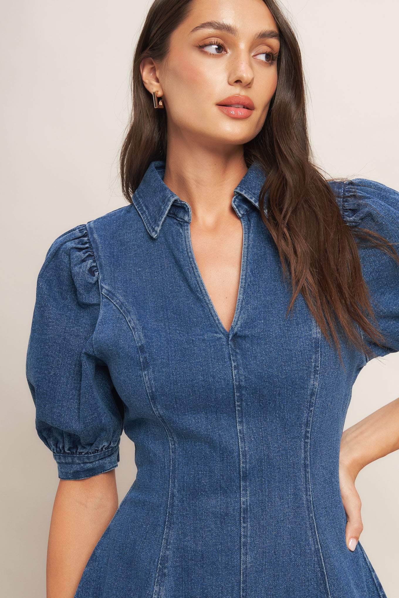 A washed denim mini dress featuring collar, front V, short puff sleeve, circle skirt and back zipper closure
