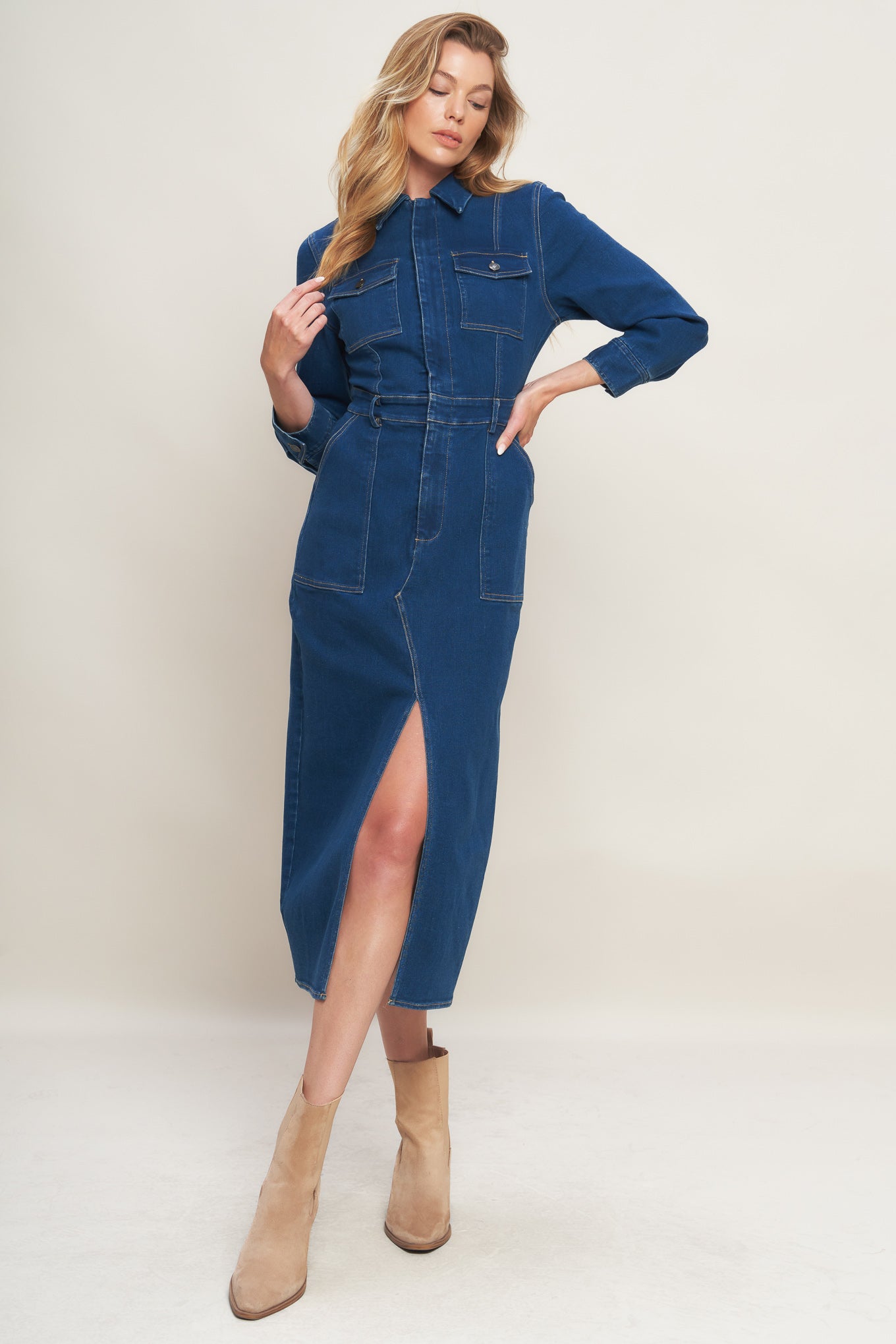 A washed denim midi dress featuring collar, hidden front zipper closure, long sleeve, front and side pockets with bottom front slit