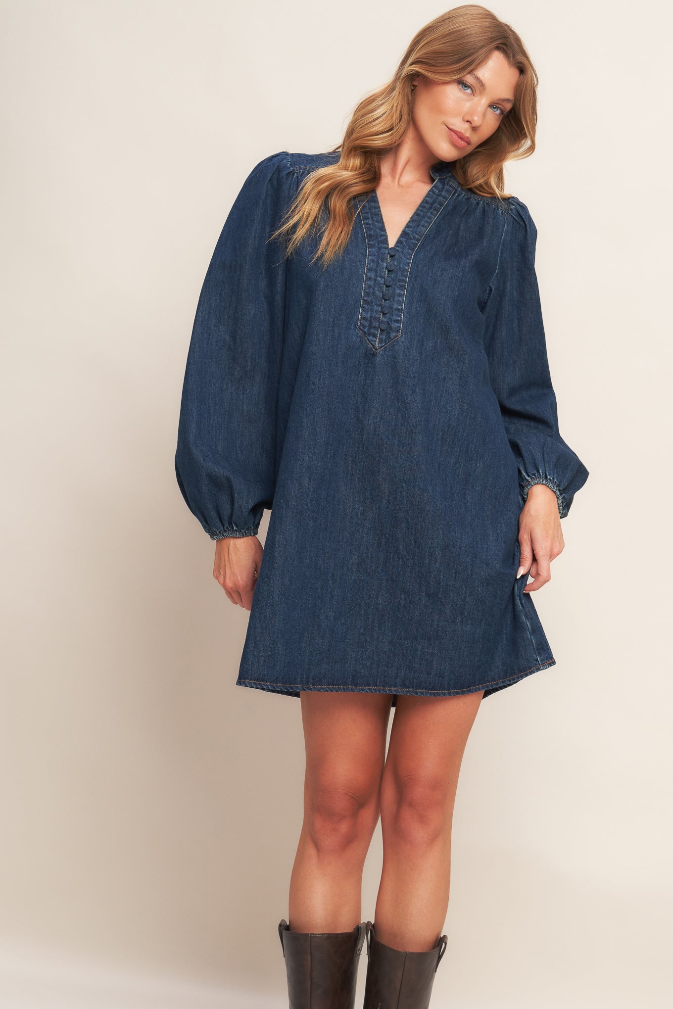 A washed denim mini dress featuring round neckline with V front, button down and long sleeve